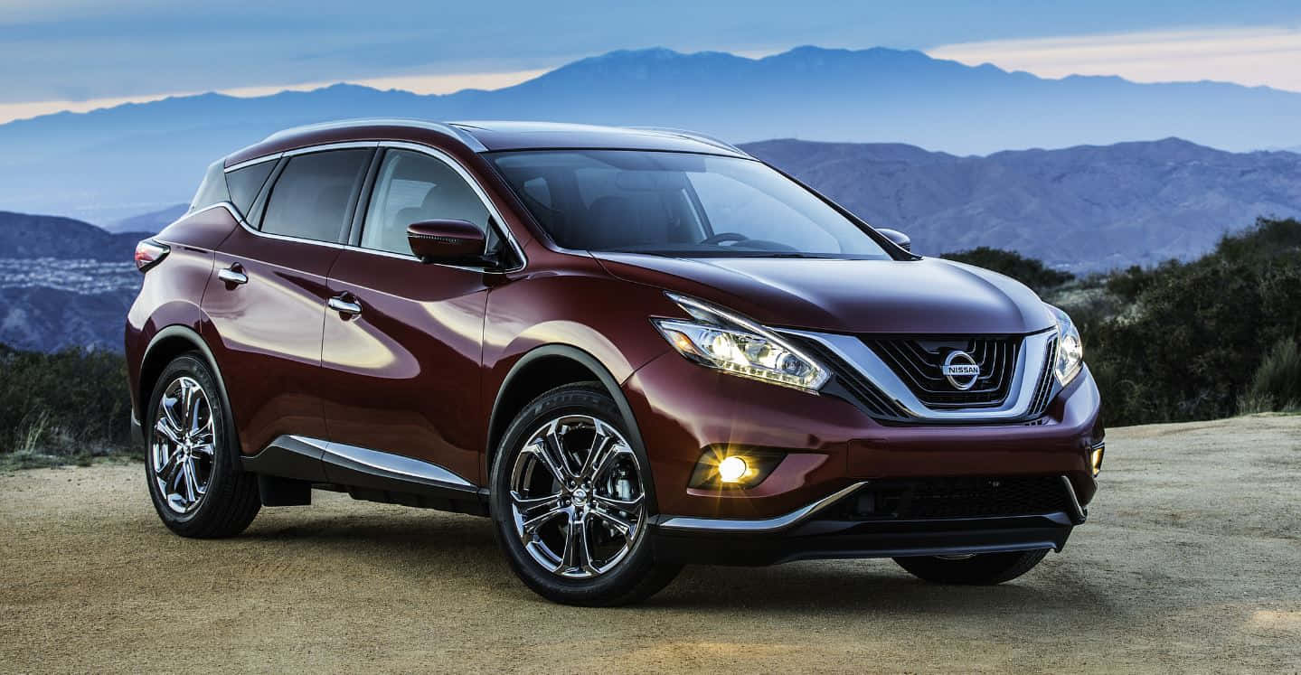 Nissan Murano 桌布 壁紙 — 一架亮面栗色日產SUV停泊在泥路上，背景有山脈，天空呈現暮色。