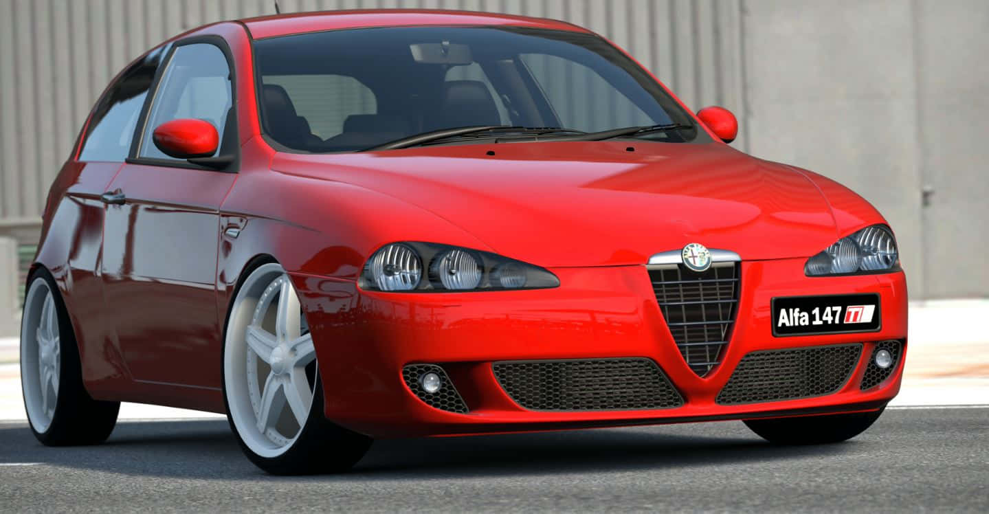 Alfa Romeo 147 桌布 壁紙 — 一輛光澤的紅色Alfa 147跑車，配白色輪圈，停在瀝青路上，背景是混凝土牆。
