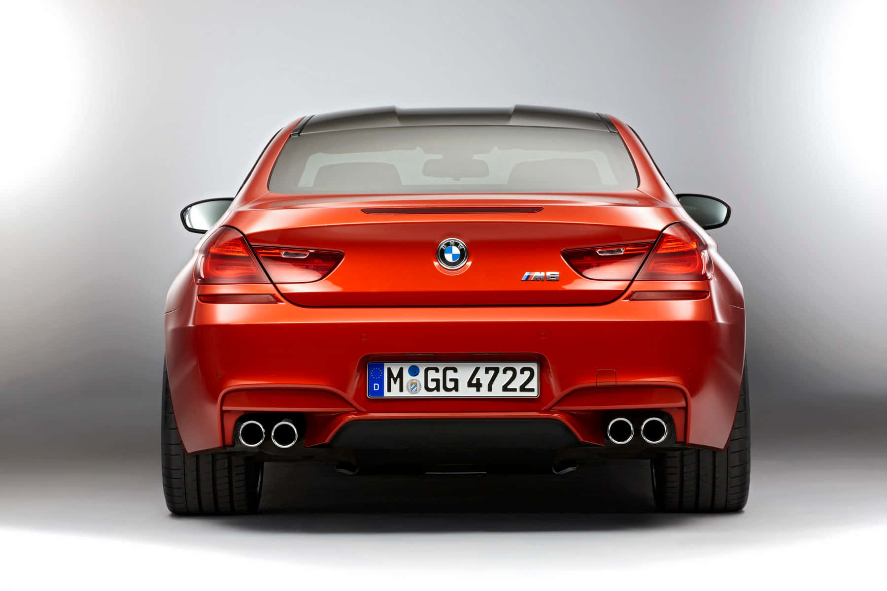 Bmw M6 桌布 壁紙 — 從後方觀看亮面紅色BMW M6轎跑車，背景為漸變灰色工作室背景。