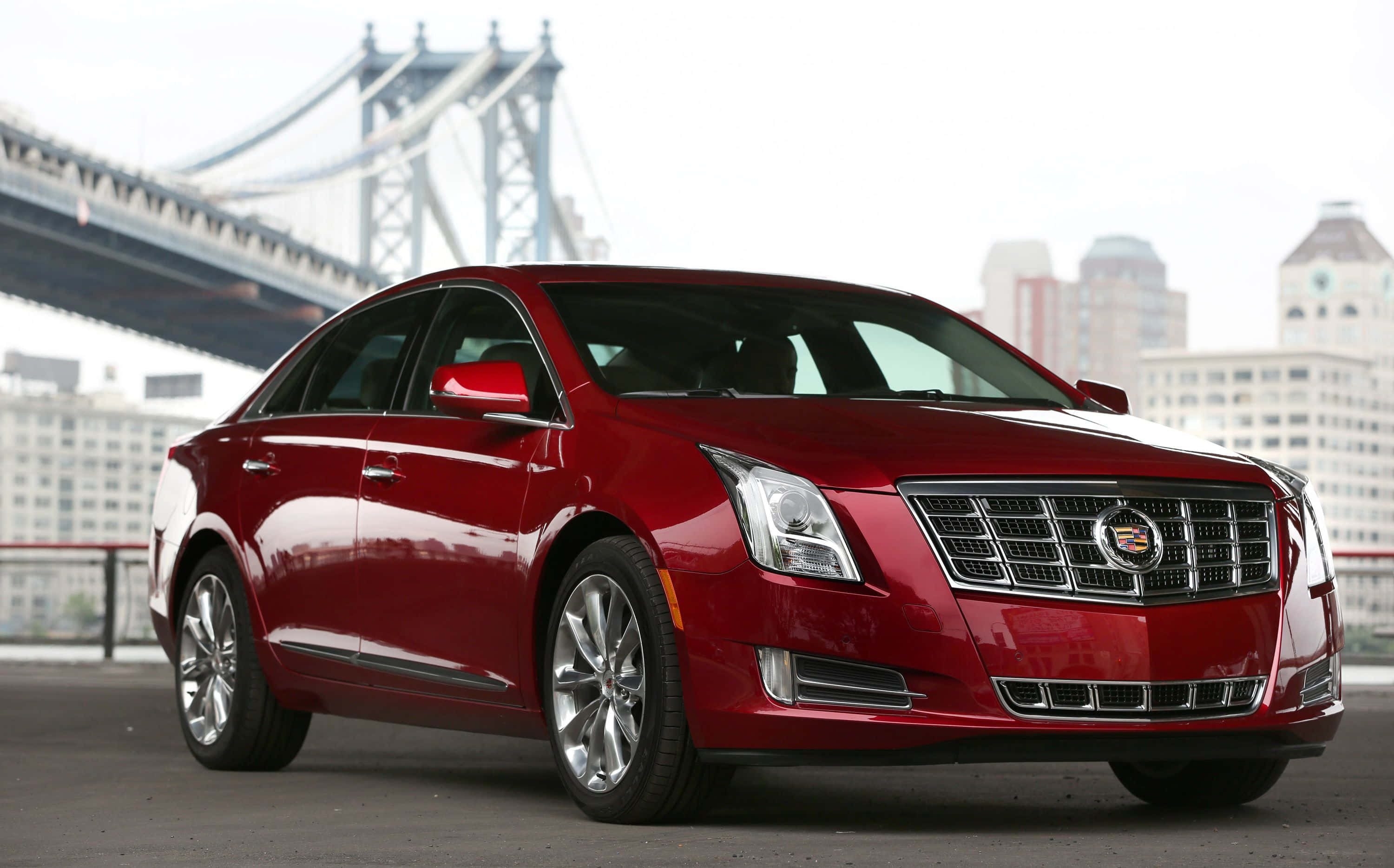 Cadillac Xts 桌布 壁紙 — 一輛亮紅色嘅卡迪拉克房車停泊喺曼哈頓大橋同城市天際線嘅背景下。