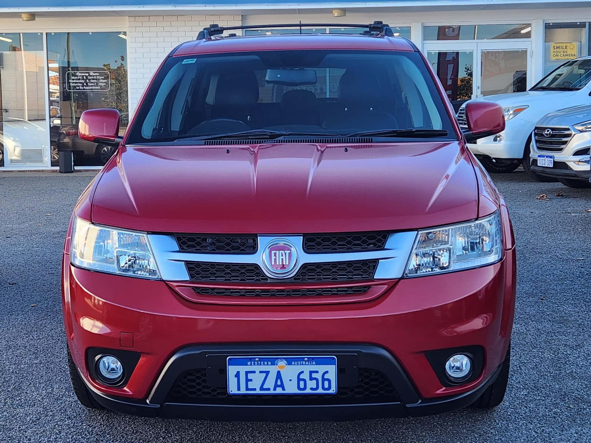  壁紙 — 一輛亮紅色Fiat SUV在經銷商場地內向前，帶有西澳洲車牌。