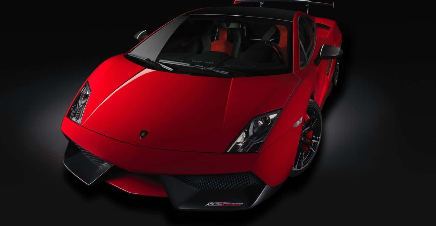Lamborghini Gallardo 桌布 壁紙 — 一輛光澤的紅色林寶堅尼Gallardo Superleggera跑車，帶有黑色飾邊和橙色內飾，在深色工作室背景下戲劇性地照明。