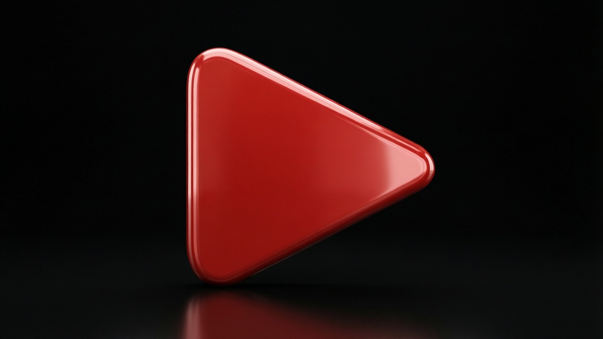 Glossy Red Play Icon 壁紙 — 一個亮面紅色播放按鈕三角形豎立在反光黑色表面上，背景為深色。