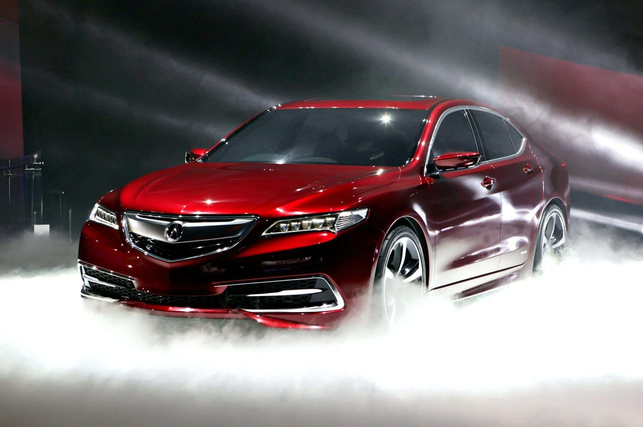 Acura Tlx 桌布 壁紙 — 一輛光亮的紅色轎車在戲劇性的舞台燈光下從旋轉的白煙中出現。