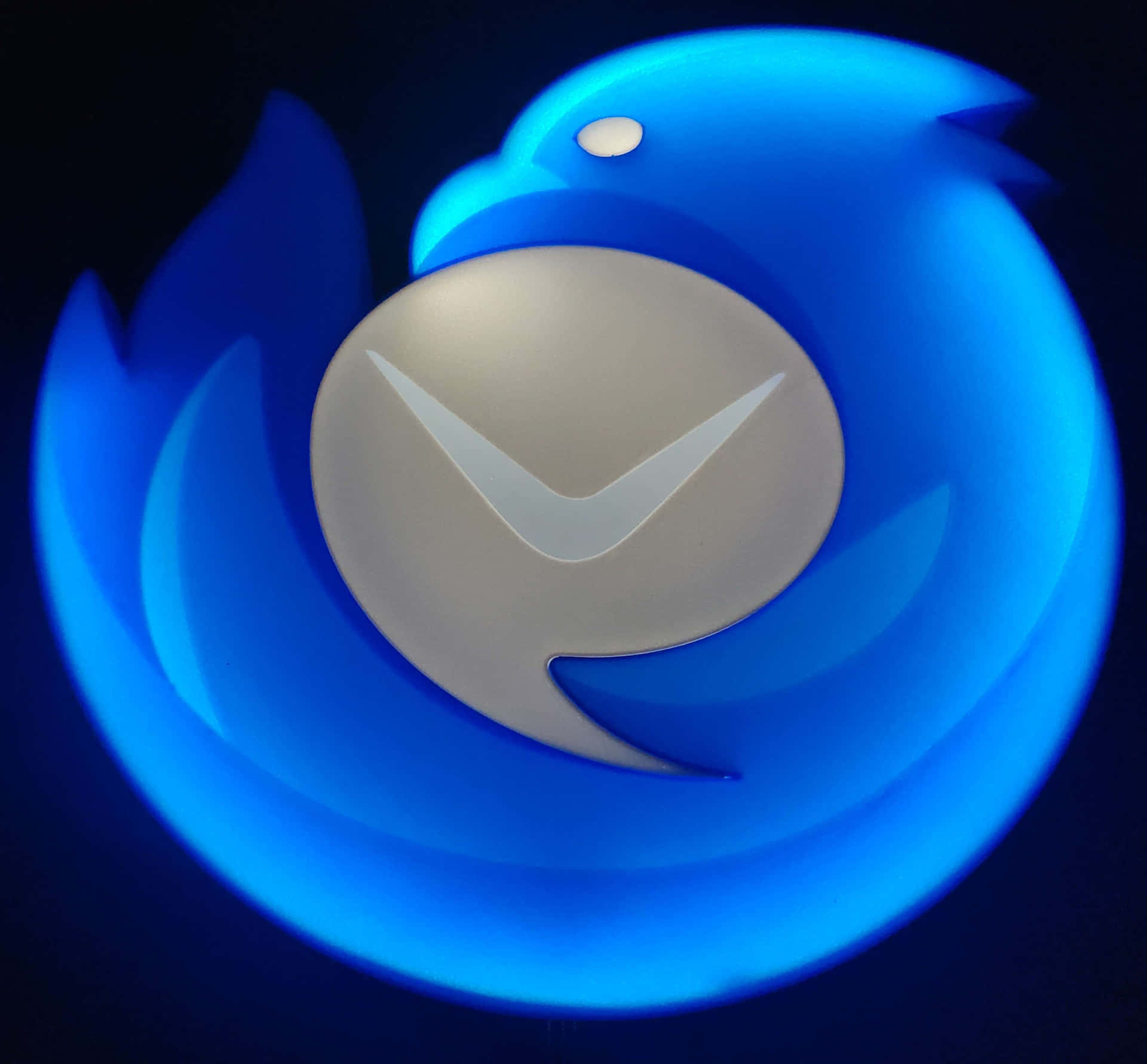 壁紙 — 在深色背景上，一個發光的藍色 Firefox 標誌，中央有白色鳥形剪影。