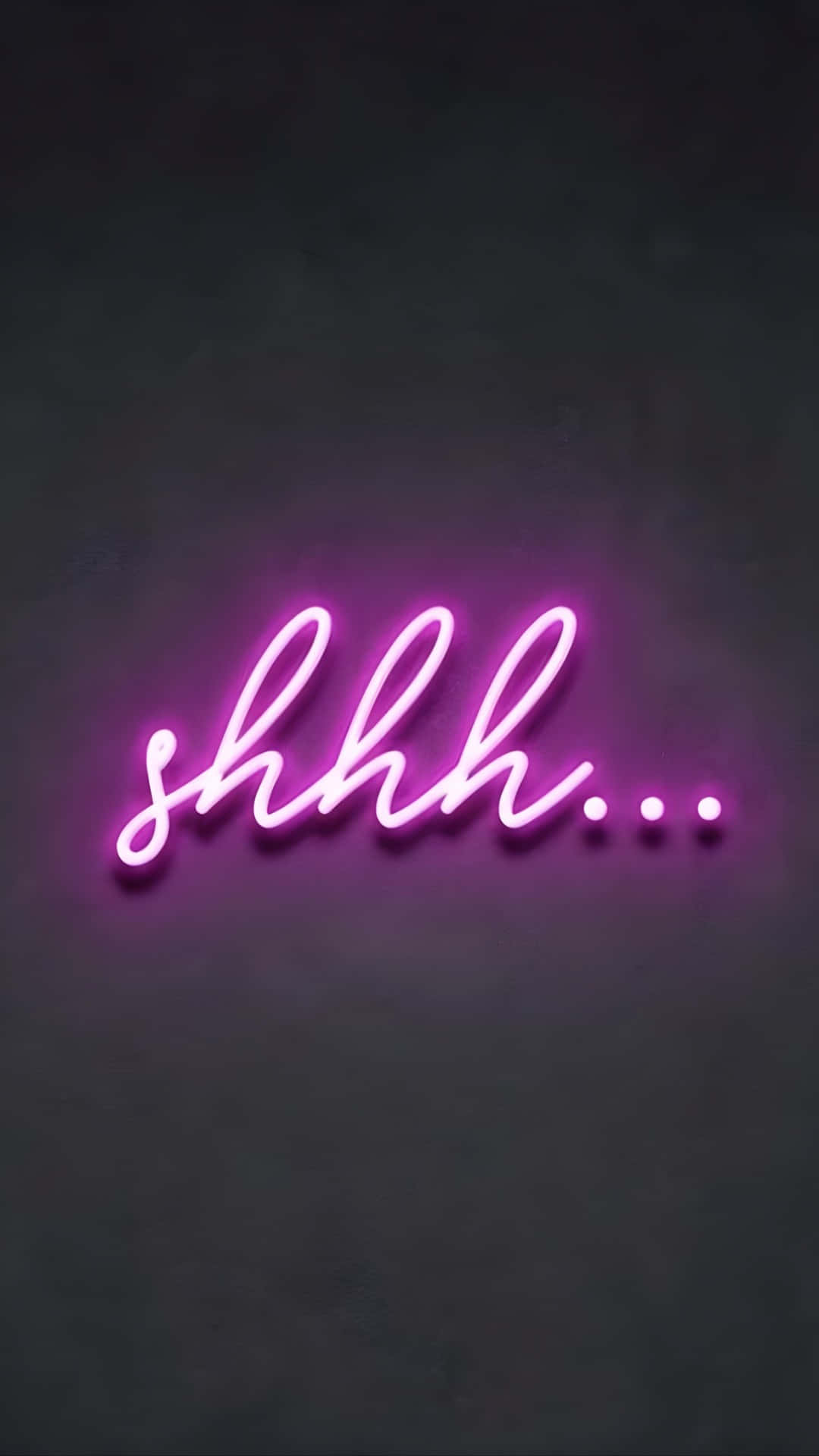  壁紙 — 一個發光的粉紅色霓虹燈牌，拼寫著「shhh...」，在深色紋理牆壁上投射出柔和的光線。