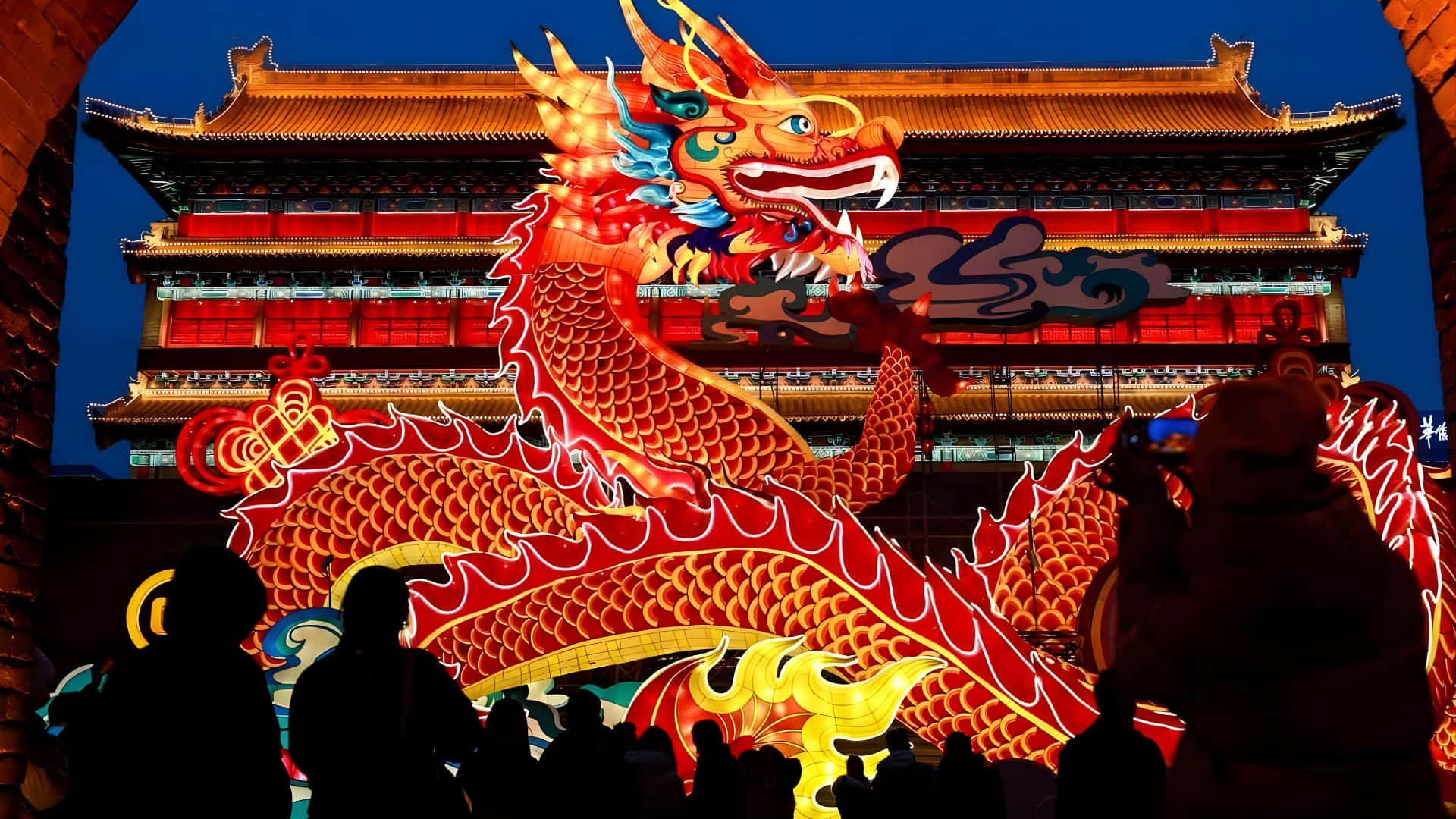  壁紙 — 一個巨大發光的紅金龍燈籠主宰著夜晚的傳統中式建築，下方有剪影般的旁觀者。