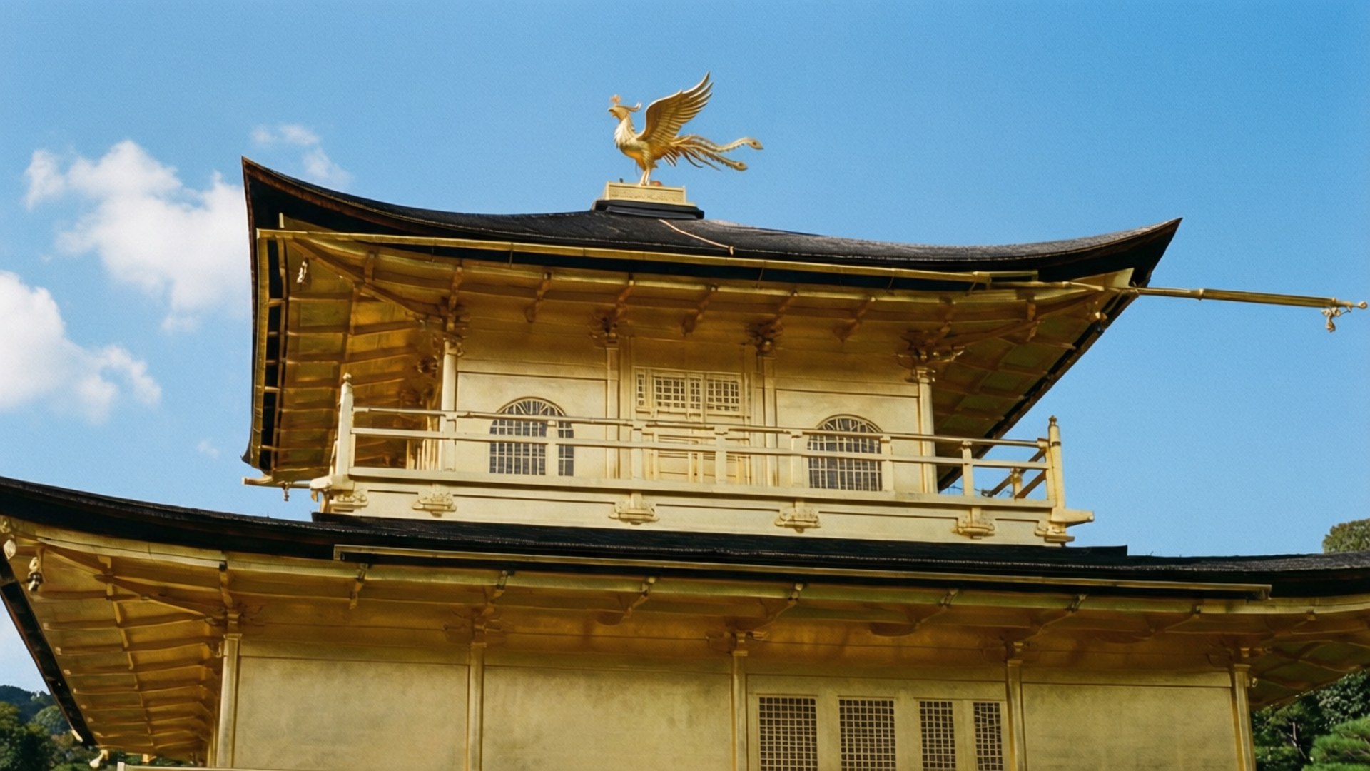 金色寺廟與鳳凰雕像在清澈藍天下