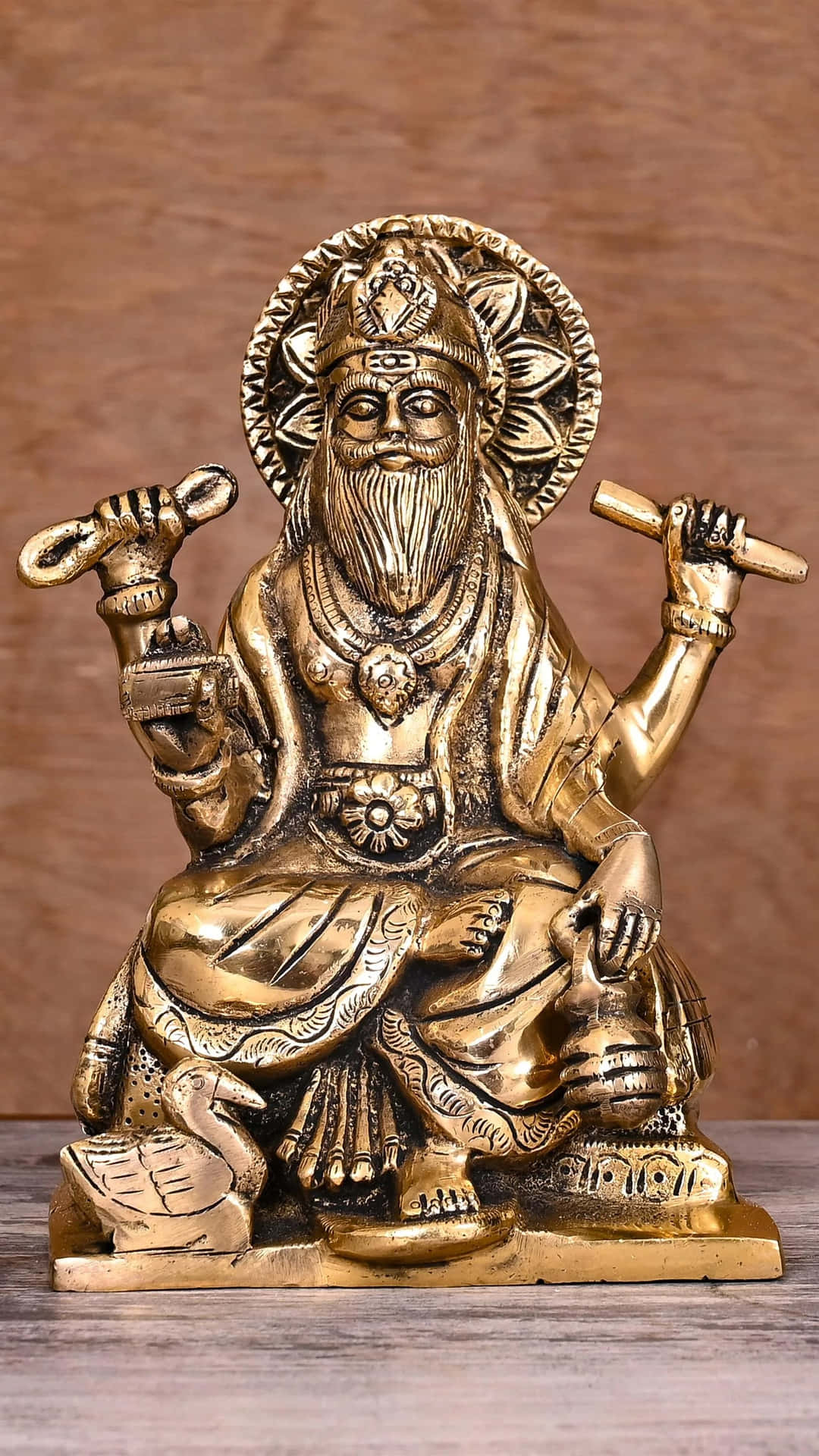  壁紙 — 金色鬍鬚神像，雕刻精細，多臂手持象徵物，以木製背景襯托。
