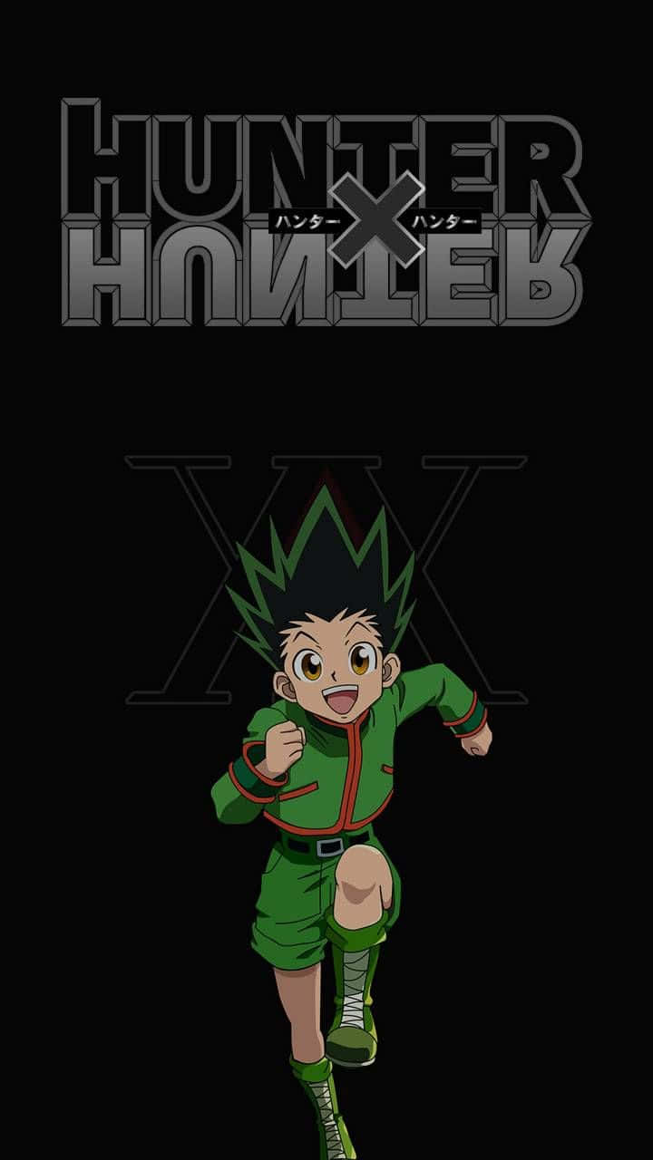 Gon Freecss 參加《獵人 X 獵人》獵人考試 壁紙 — 一個穿著綠色衣服的開朗動畫男孩在黑色背景上的 Hunter x Hunter 標誌下向前奔跑。