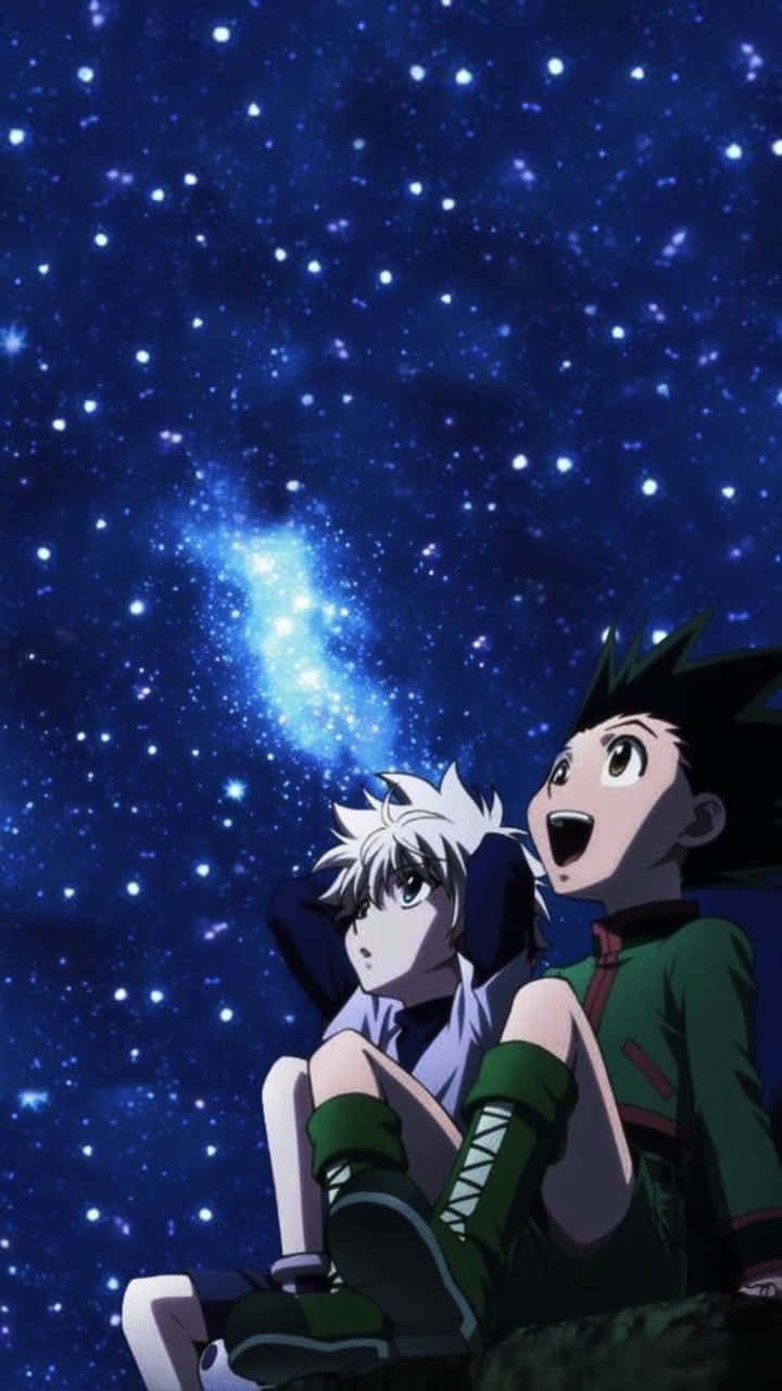 Gon 與 Killua 在《全職獵人》中施展超級連招 壁紙 — 兩個動漫角色敬畏地仰望充滿發光天體的鮮豔星空夜空。