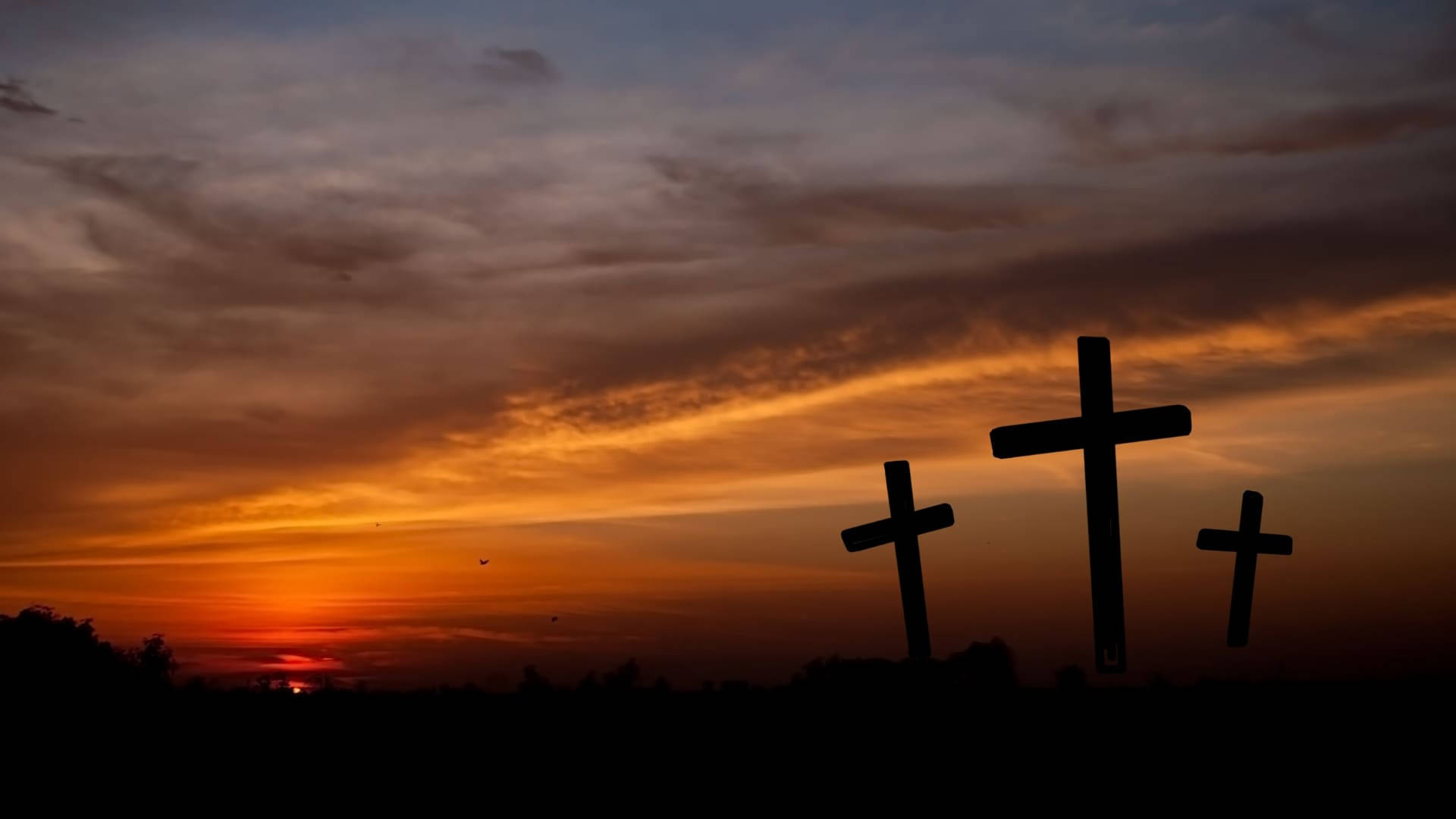 Good Friday 聖日落 壁紙 — 三個十字架在橙紫色雲彩的熾熱日落天空襯托下形成剪影。