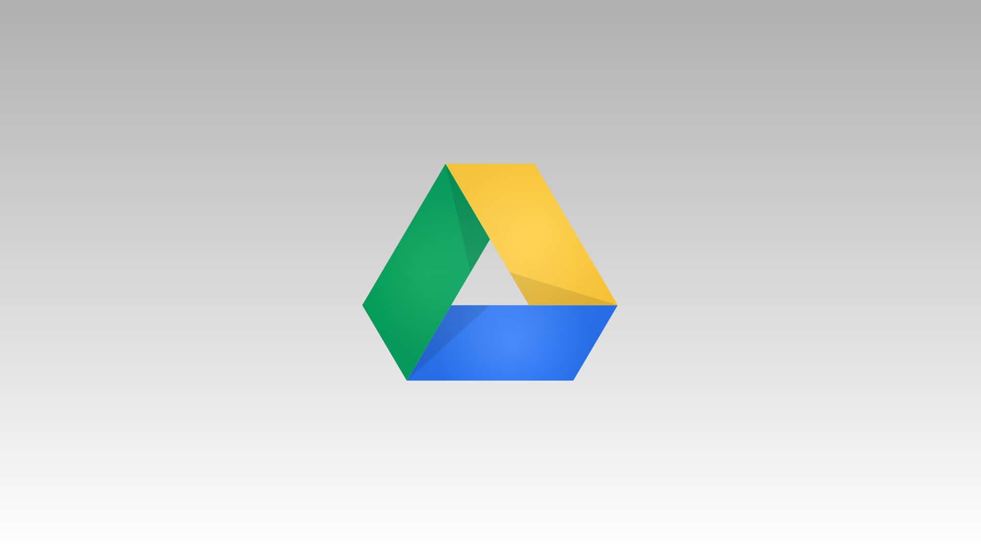 Google Drive 最簡約圖標 壁紙 — 一個色彩繽紛的Google Drive標誌，中央有綠色、黃色和藍色的三角形部分，置於柔和的灰色漸變背景上。
