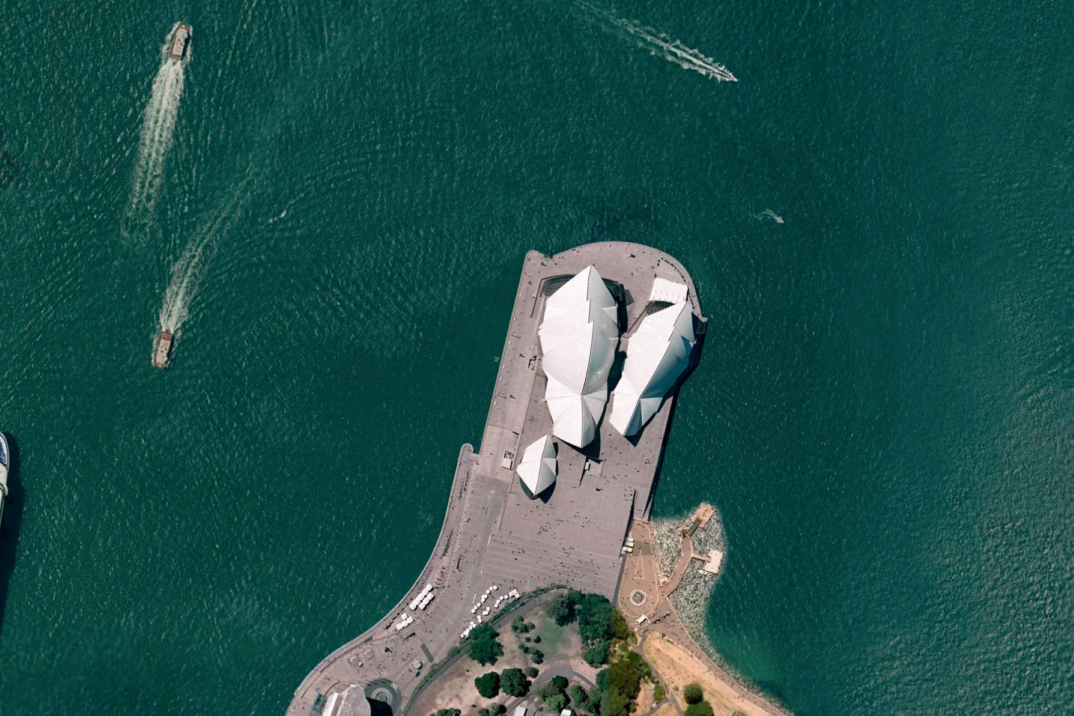 Google Earth 悉尼歌劇院 壁紙 — 悉尼歌劇院的鳥瞰圖，碧綠的海水和附近的船隻。