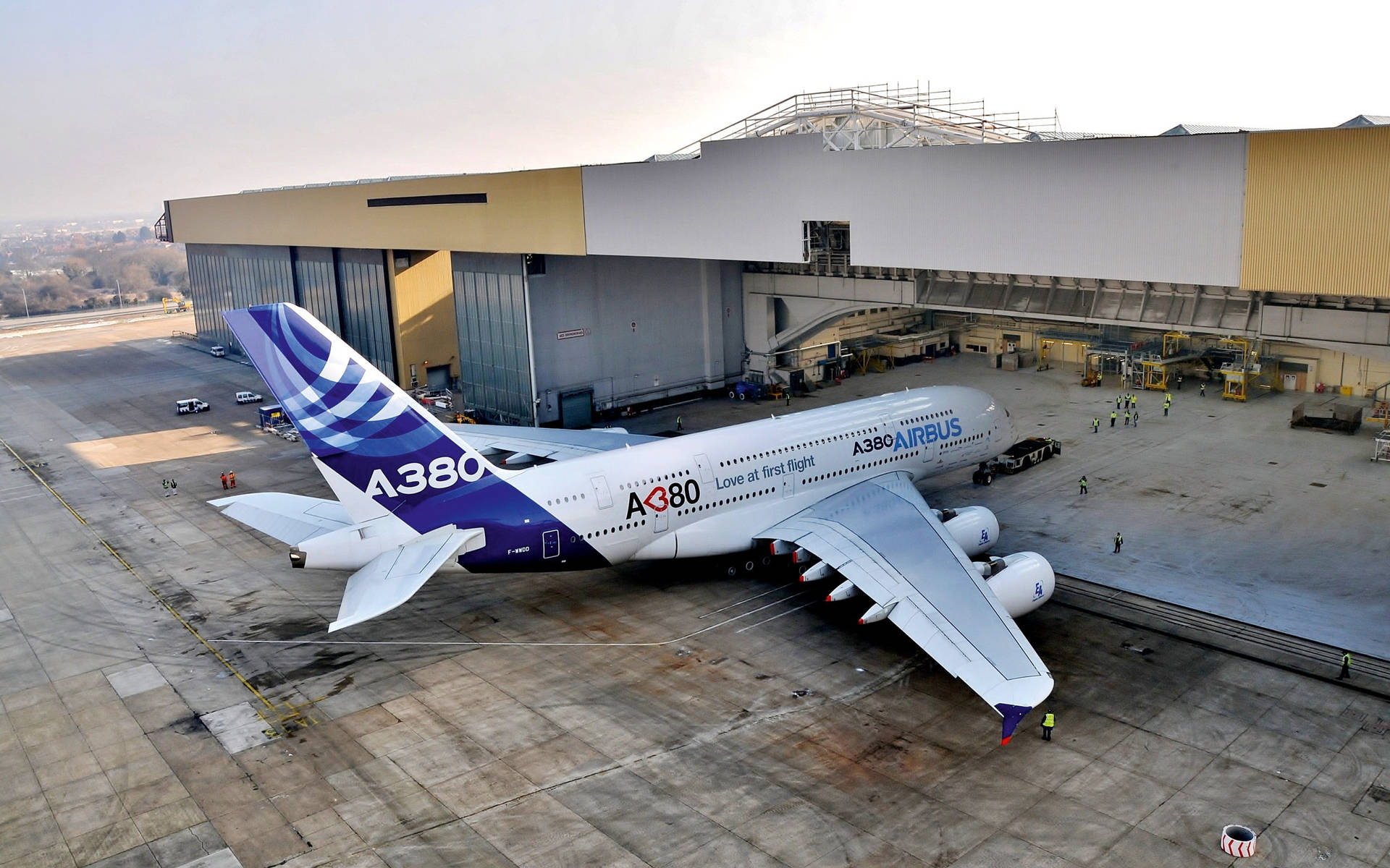 空中巴士A380飛機停在機庫外停機坪，有地勤人員