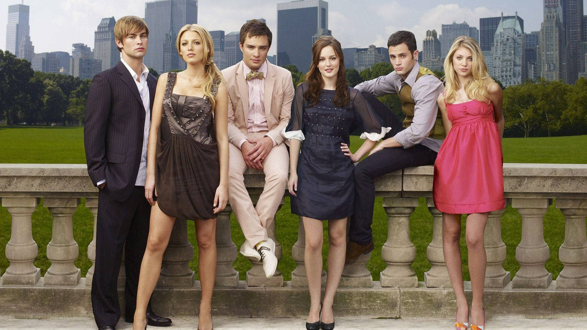 《Gossip Girl》主要演員群像 壁紙 — 六位衣著時尚的年輕人自信地站在石欄杆上，背景是鬱鬱蔥蔥的公園和高聳的城市天際線。