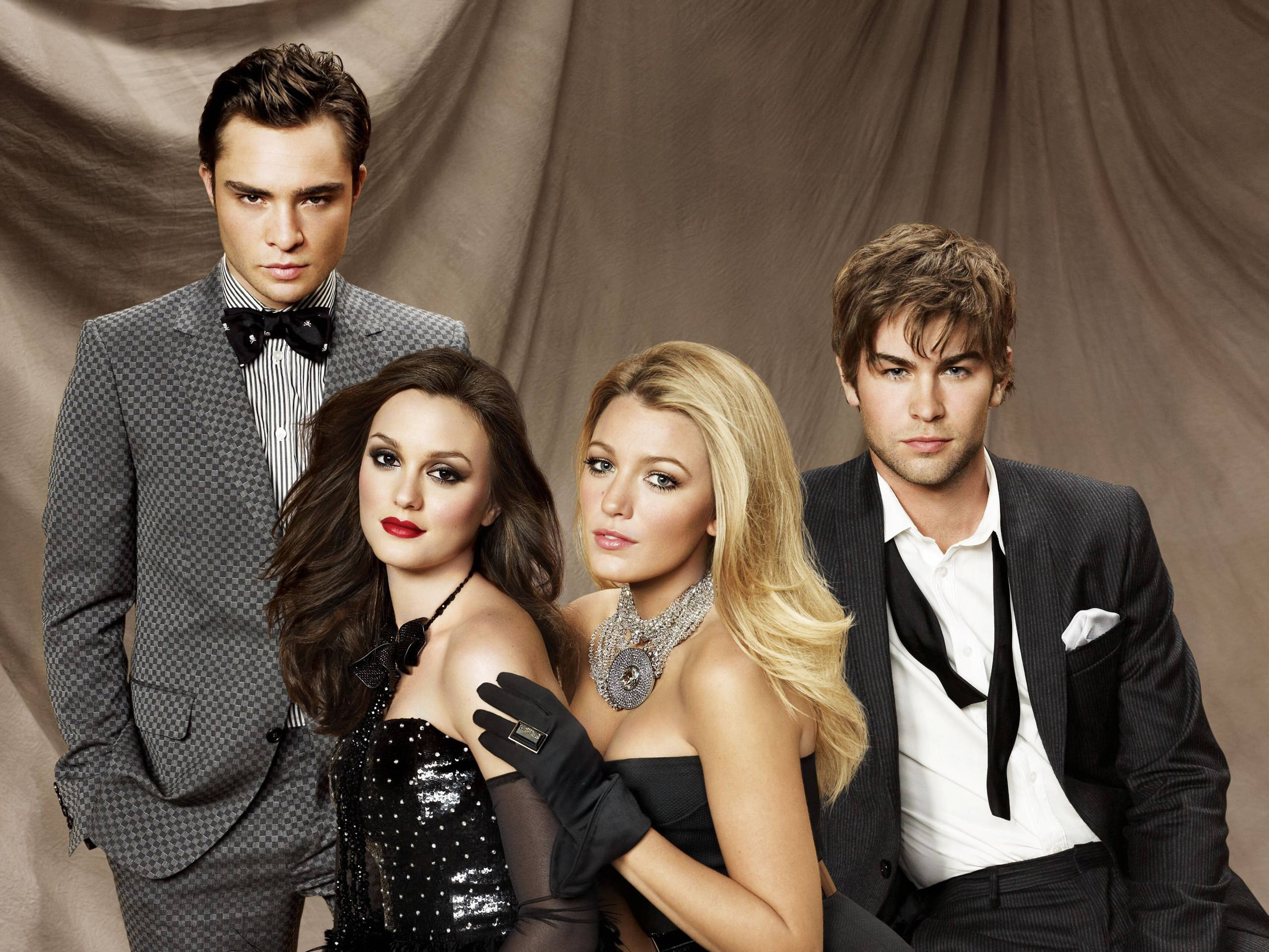 Gossip Girl 高級攝影 壁紙 — 四位衣著優雅的名人自信地擺姿勢，背景是垂墜的灰褐色布幕，營造出迷人的攝影棚肖像。