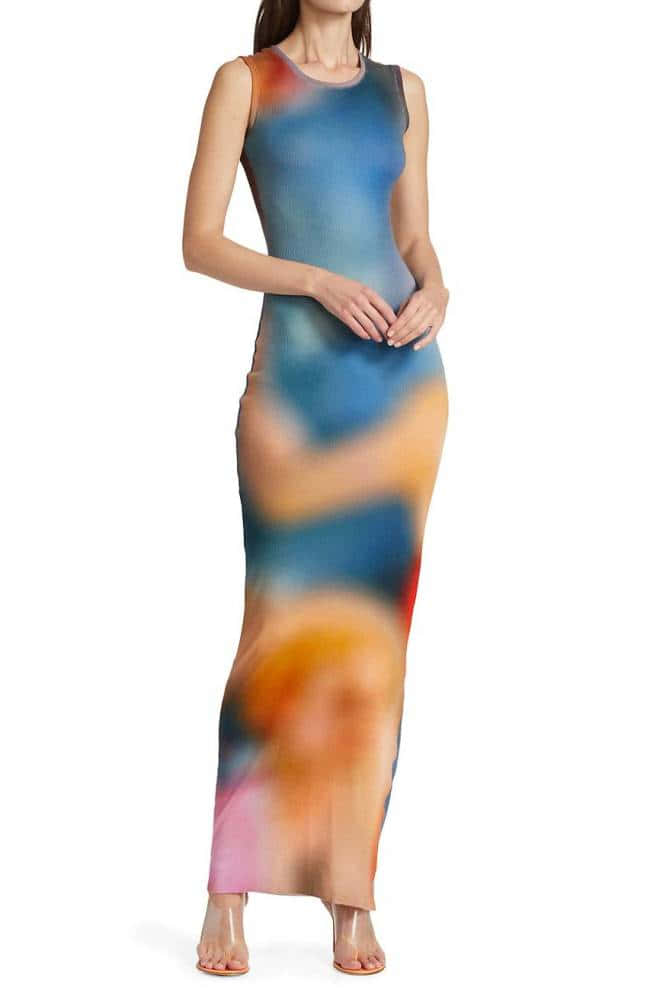 用 Gradient 的多彩設計工具激發創意 壁紙 — 一位女士穿著一件貼身連衣裙，上面有藍色、橙色和粉紅色的鮮豔抽象水彩印花，背景是純白色。