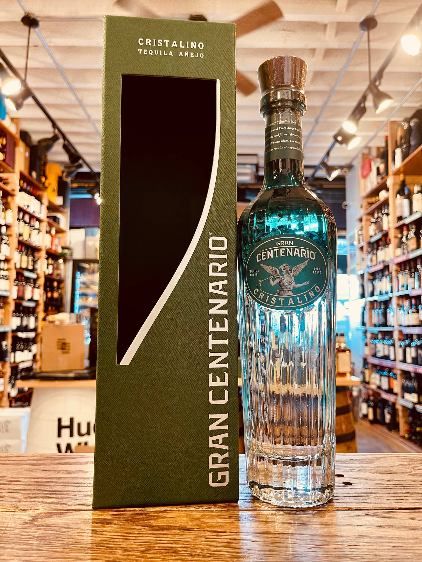 Gran Centenario Cristalino龍舌蘭酒瓶和盒子在酒類商店的木製櫃檯上。