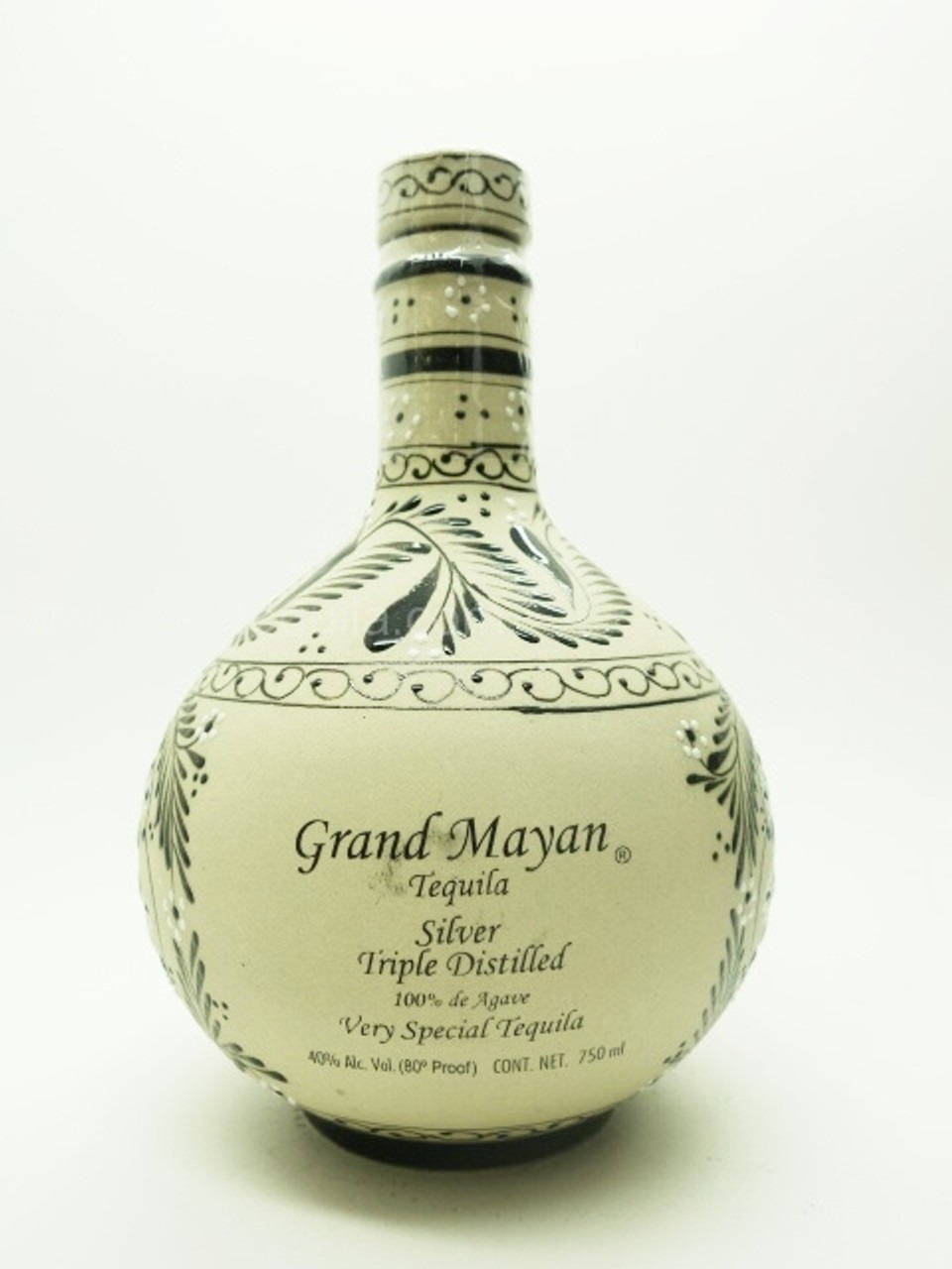 Grand Mayan 銀色蒂基拉三重蒸餾瓶裝攝影 壁紙 — 一個奶油色的Grand Mayan龍舌蘭酒瓶，帶有黑色華麗圖案和文字，立在純白色背景前。