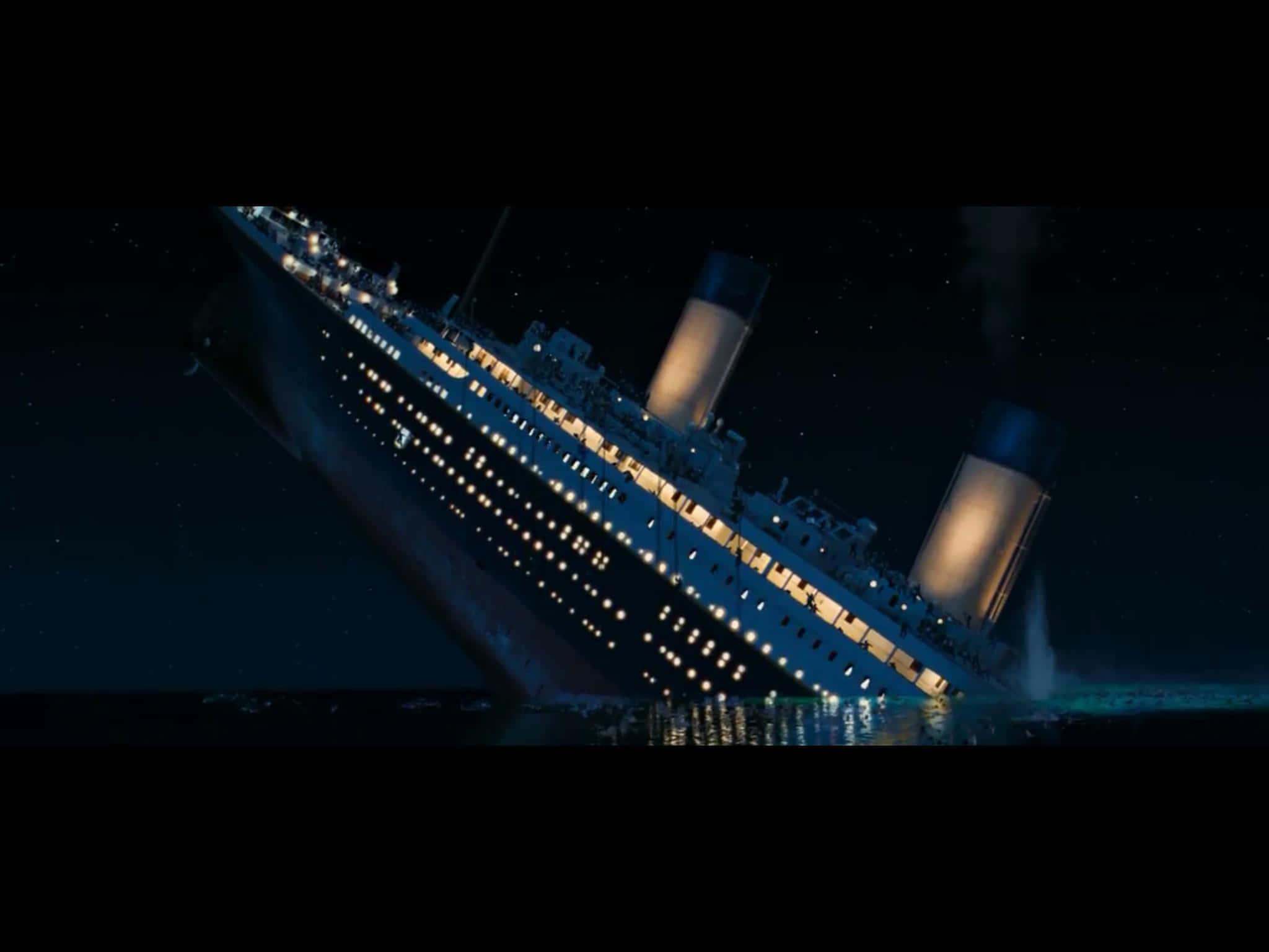 Titanic Wreck 桌布 壁紙 — 一艘大型遠洋郵輪在夜間戲劇性地傾斜，在星空下沉入冰冷的海水中。