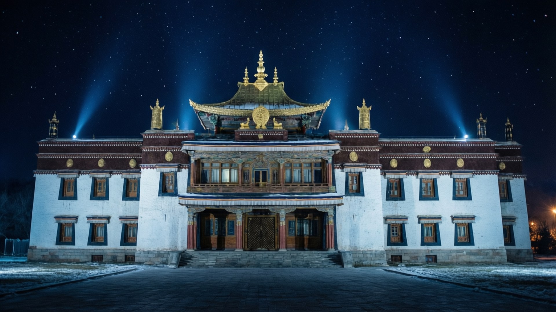Illuminated Palace Night 壁紙 — 一座宏偉的西藏寺院在繁星點點的冬夜天空下被聚光燈照亮，地上有積雪。