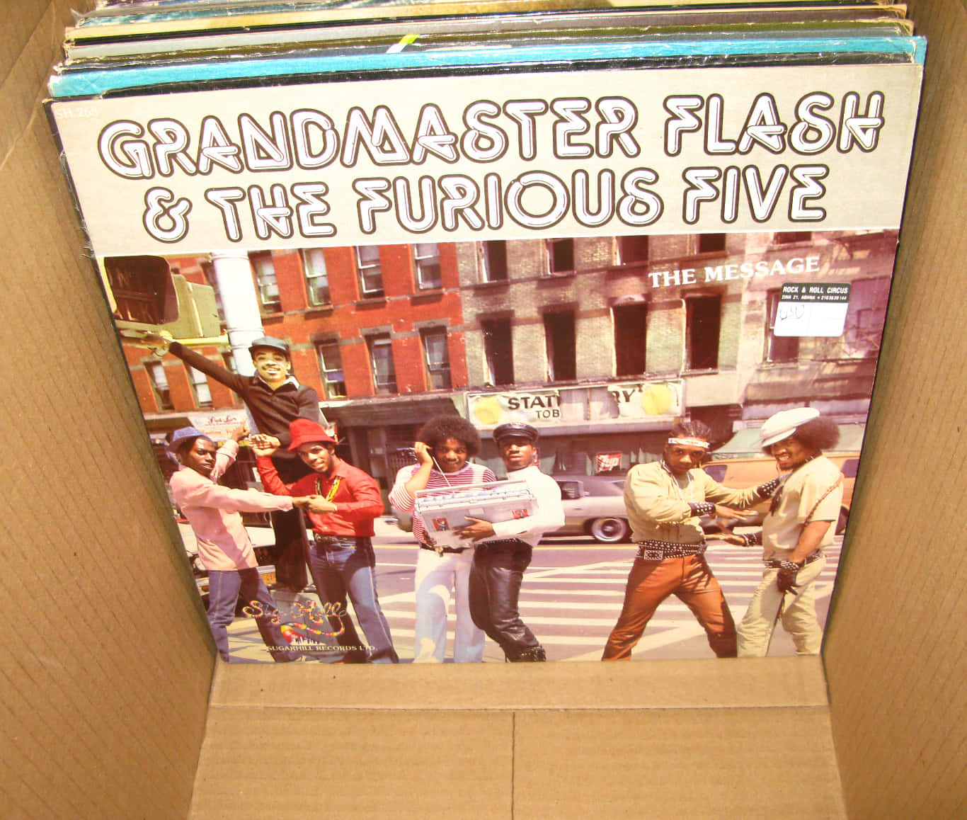 Grandmaster Flash And The Furious Five 黑膠唱片 壁紙 — Grandmaster Flash & The Furious Five 的復古專輯封面，放在紙板箱內，展示街頭場景及粗體字型。