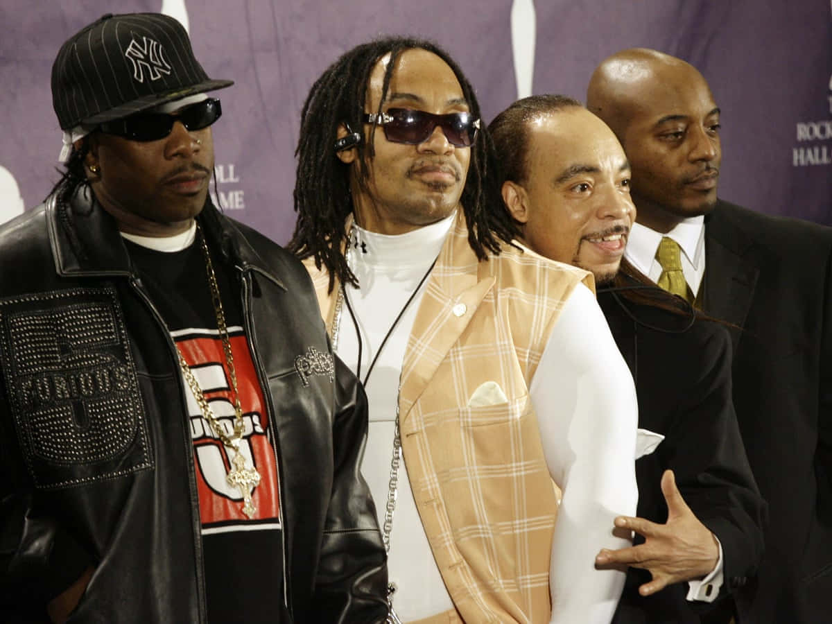 Grandmaster Flash 和 The Furious Five 的 Kidd Creole 壁紙 — 四位標誌性嘻哈藝術家在紫色背景下自信地於搖滾名人堂擺姿勢，戴著太陽眼鏡和時尚服裝。