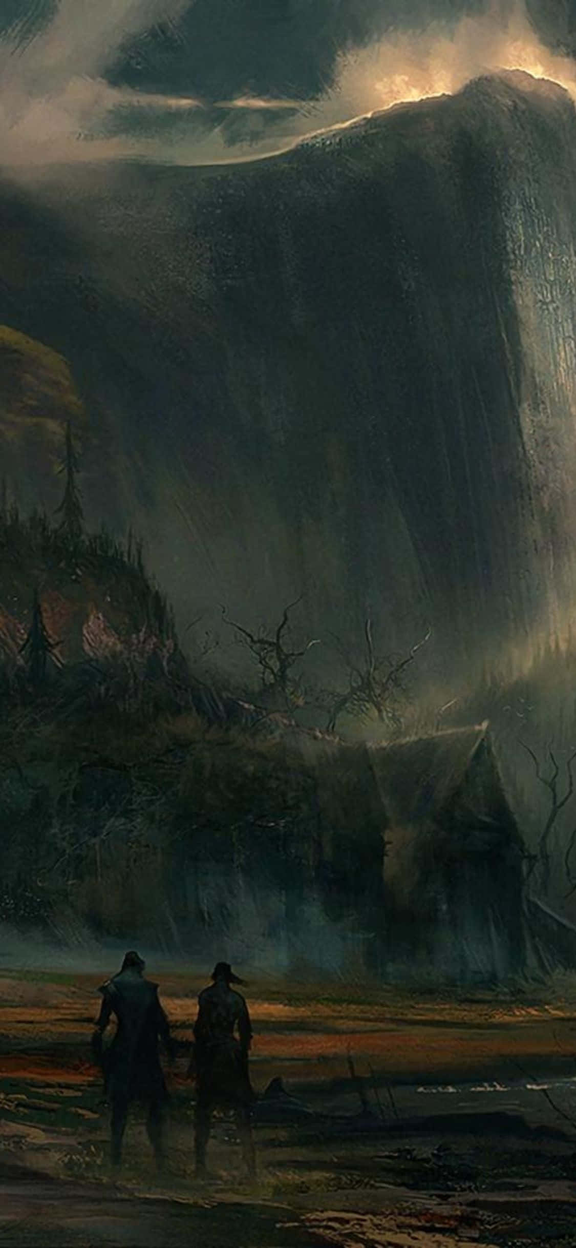 《Greedfall》角色山景藝術圖，適用 iPhone X 背景 壁紙 — 兩個披著斗篷的身影站在一座搖搖欲墜的小屋前，背後是迫近的暴風雨山巒，金色光芒穿破雲層。
