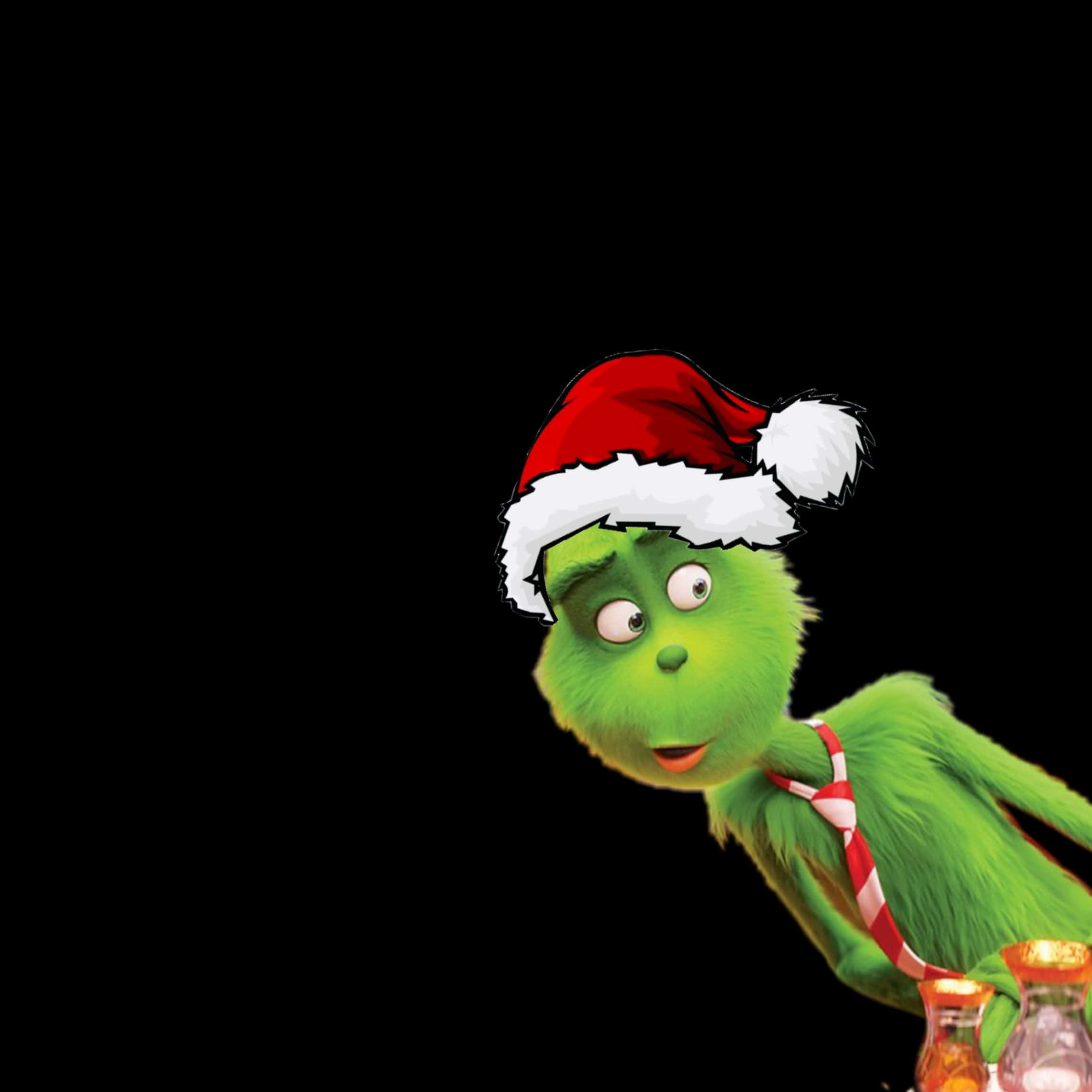 Cute Grinch 桌布 壁紙 — 一隻綠色的鬼靈精戴着紅色聖誕帽和糖果手杖領帶，在黑色背景右側好奇地窺視。
