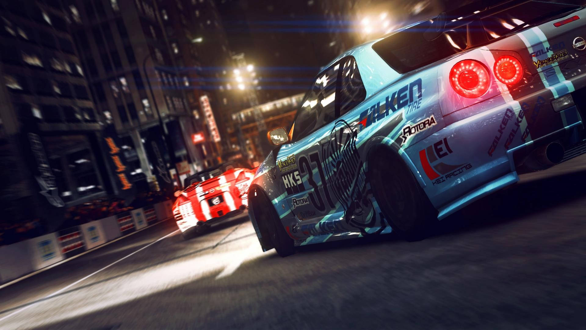 Grid 2 夜間競速 壁紙 — 一輛帶有紅色尾燈的藍色賽車在夜間穿過霓虹燈照亮的城市街道，追逐一輛紅色汽車。