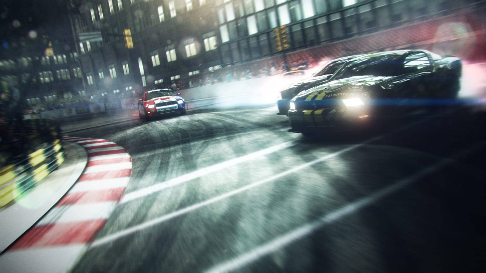 Grid 2 夜間賽道 壁紙 — 兩輛賽車在夜間濕滑的城市街角漂移，伴隨著發光的車頭燈和動態模糊效果。