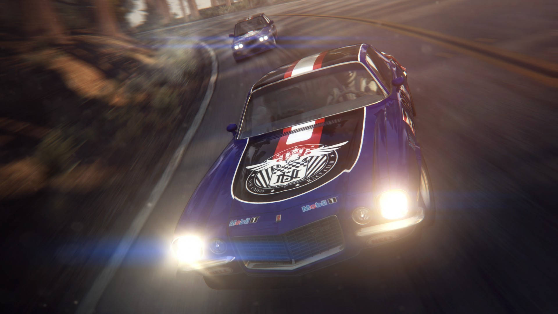 Grid 2 藍色賽車 壁紙 — 一輛帶有紅色和白色條紋的藍色賽車在夜間沿著蜿蜒的道路疾馳，車頭燈亮著。
