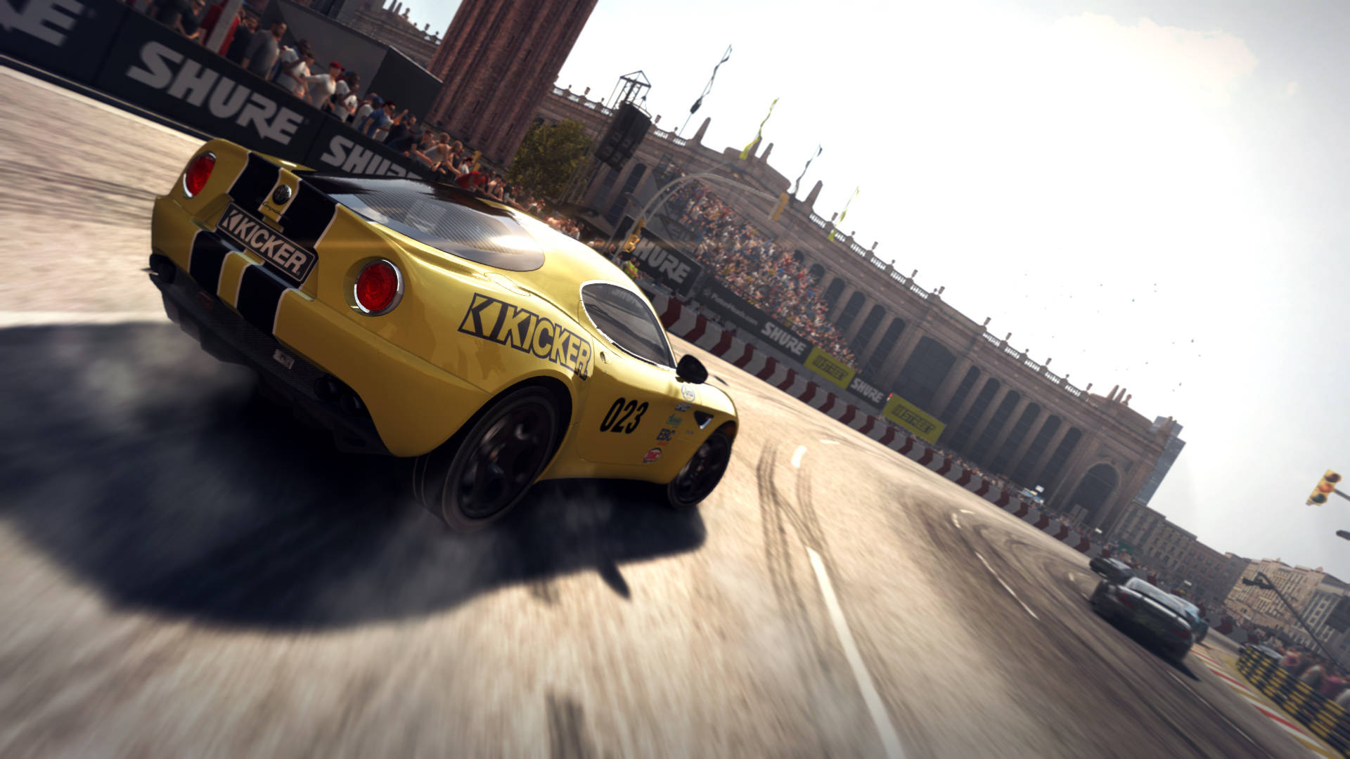 Grid 2 賽車競技 壁紙 — 一輛黃色賽車在陽光明媚的城市賽道上飄移，背景是歡呼的人群和歷史建築。