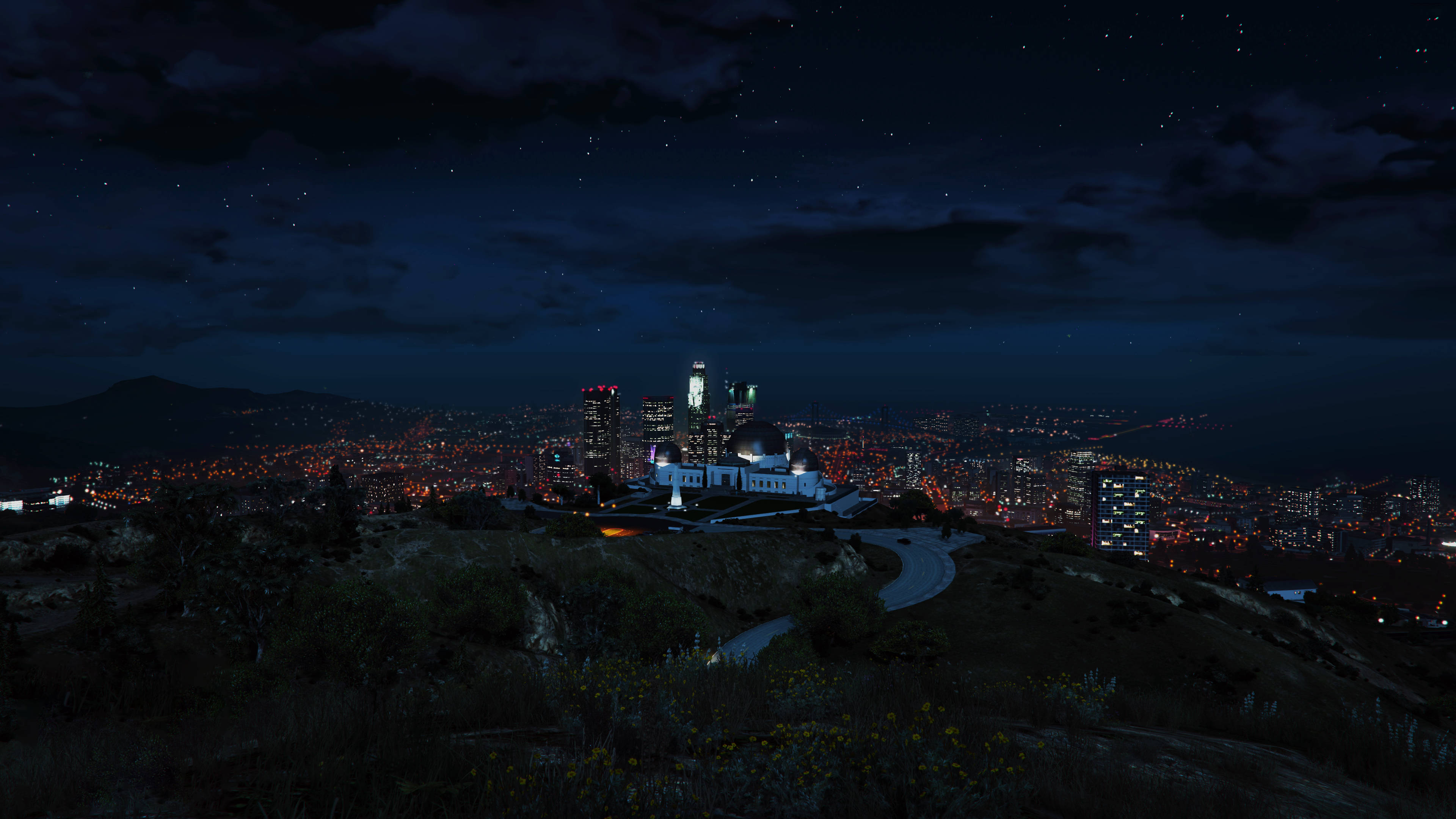 GTA V 加利略天文台夜景 壁紙 — 從山頂俯瞰繁星點點的廣闊城市景觀，下方有閃爍的燈光和蜿蜒的道路。