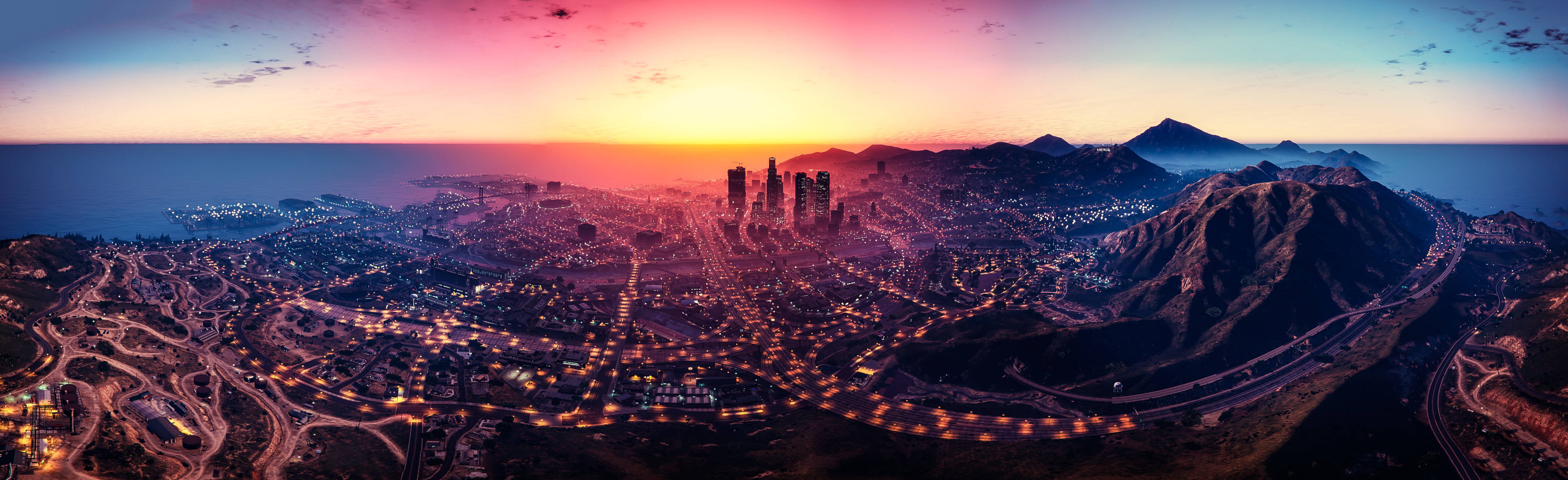 GTA V 洛聖都全景夜景 壁紙 — 全景日落景觀，展現一座坐落於山脈之間的廣闊沿海城市，街道和建築物閃爍著光芒。