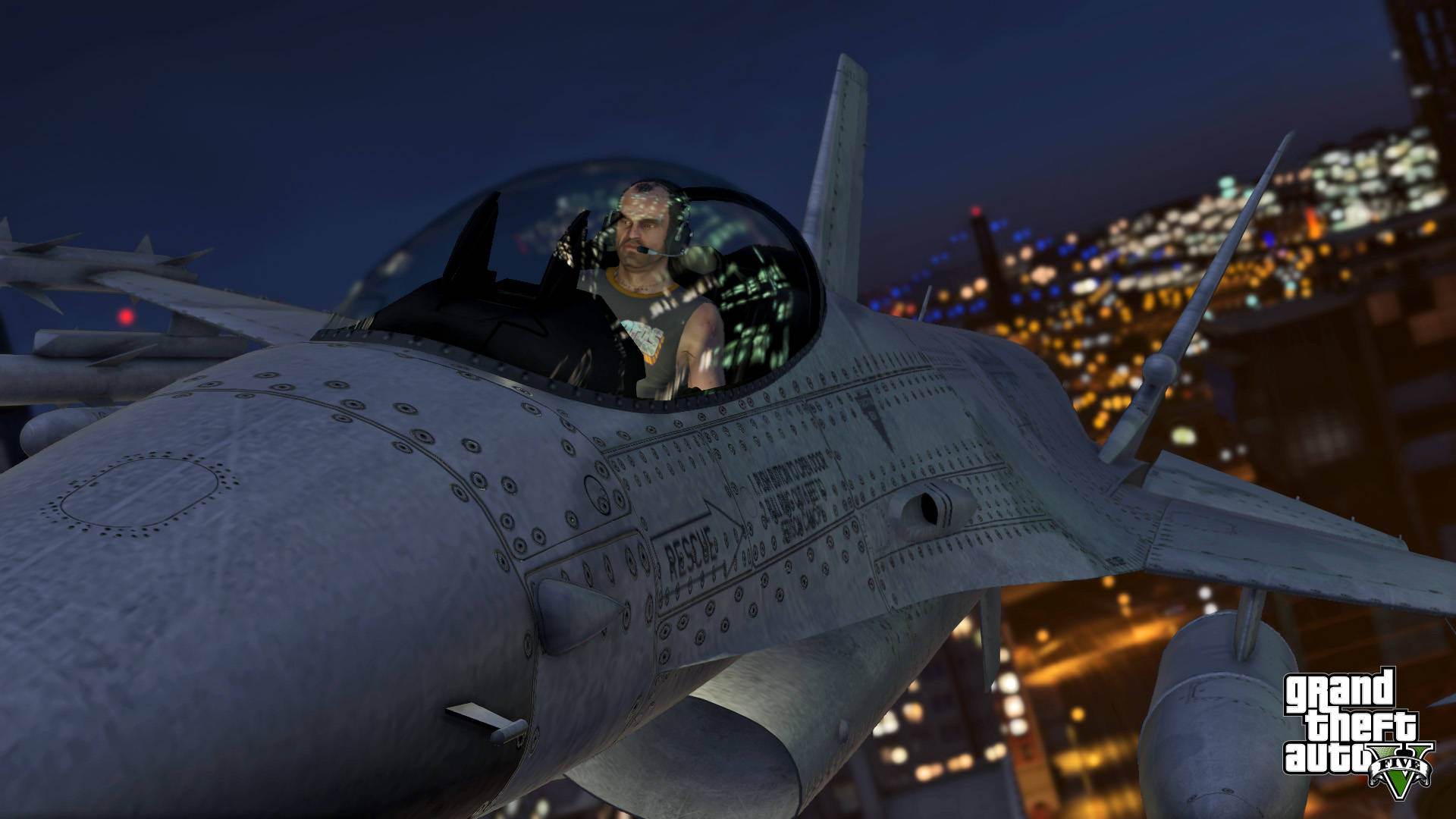 GTA V 特雷弗駕駛噴射機 壁紙 — 一架戰鬥機與飛行員在夜間低飛過霓虹燈照亮嘅城市景觀，係一個電玩遊戲場景。