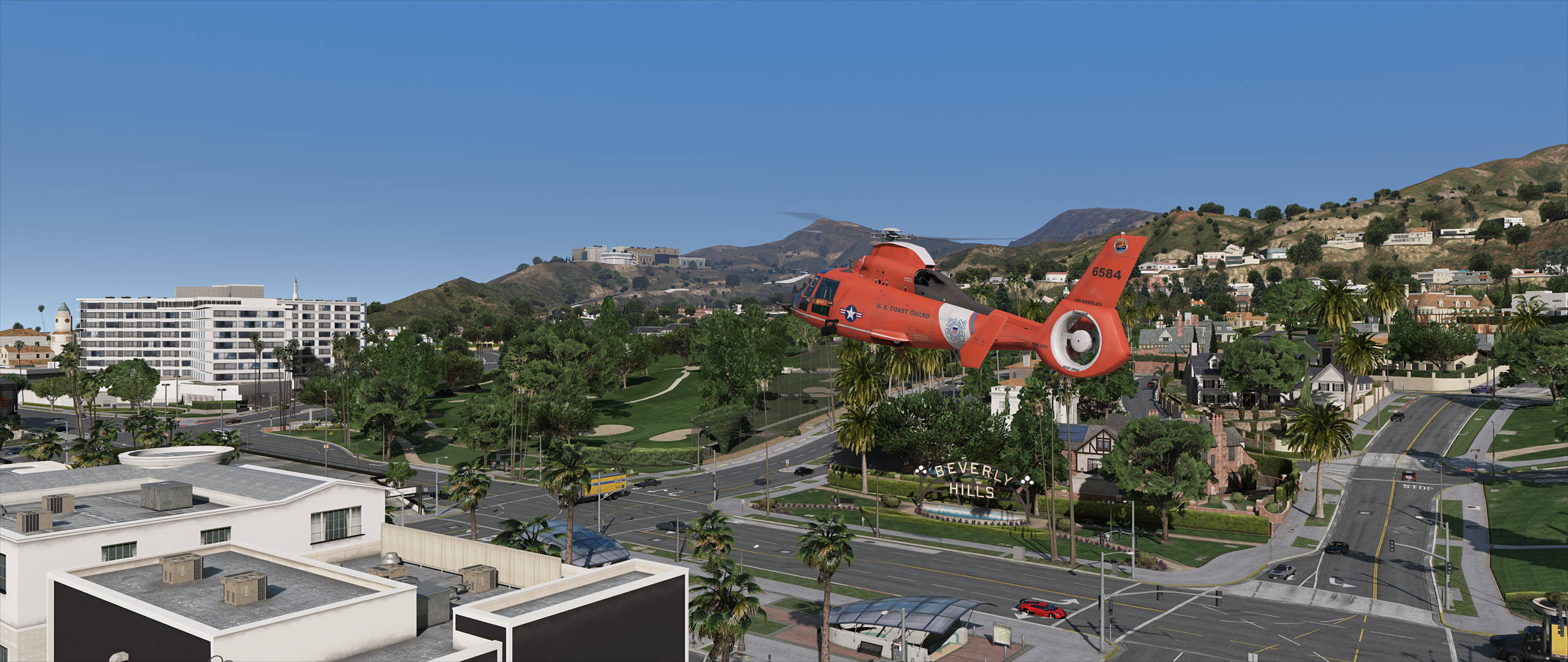 GTA V 紅色直升機飛行 壁紙 — 一架亮橙色的海岸警衛隊直升機低飛過陽光明媚的比華利山莊街道，背景有棕櫚樹和山丘。