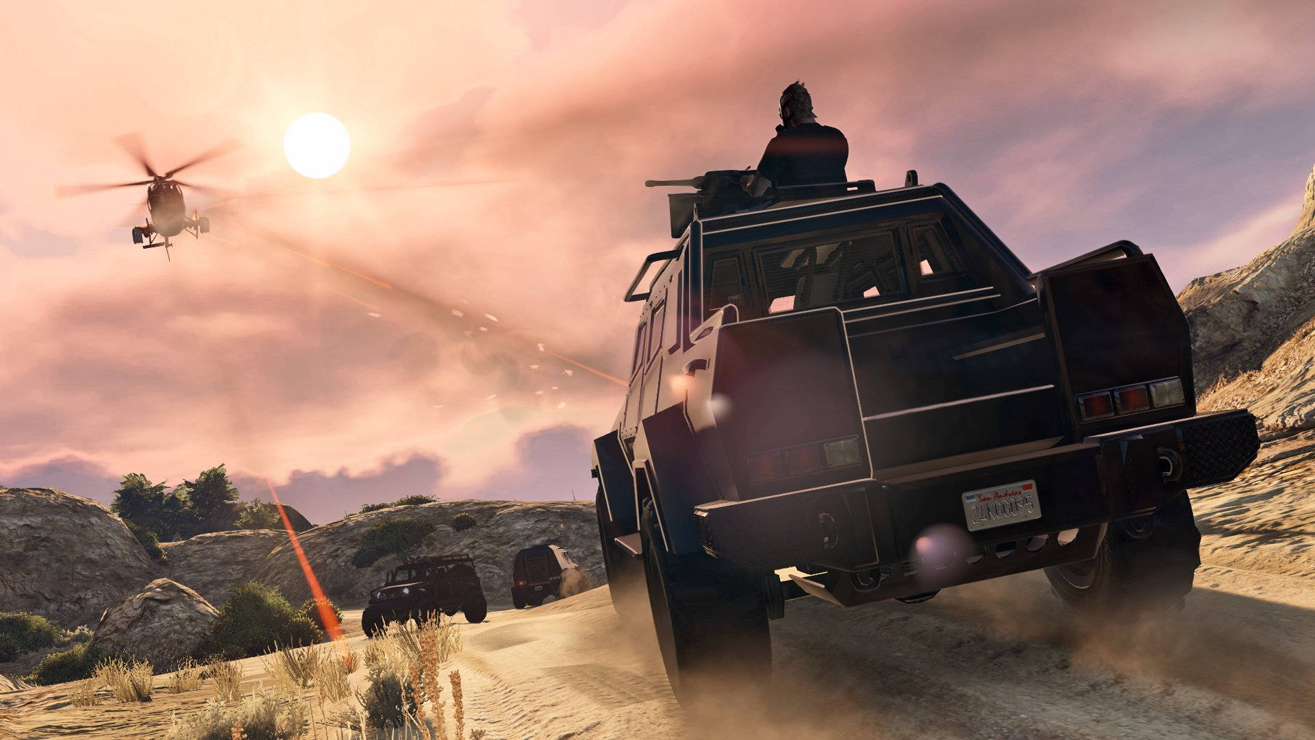 GTA V 越野車對決直升機 壁紙 — 一架黑色裝甲車在沙漠中疾馳，在燦爛的夕陽下揚起塵土，一架直升機在頭頂飛過。