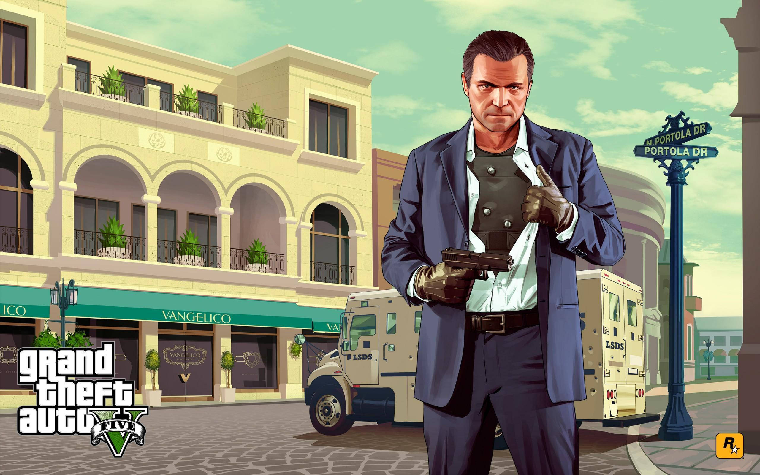GTA V 麥克穿防彈背心 壁紙 — 一個嚴肅的男人穿著藍色西裝，在陽光明媚的城市街道上拿著槍，旁邊有裝甲車和地中海風格的建築。