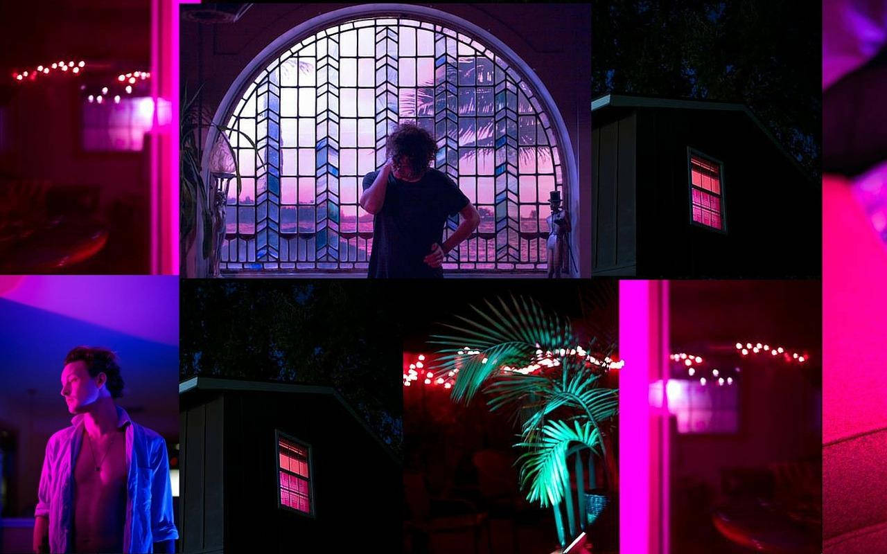 夜晚霓虹燈下，彩繪玻璃窗旁的人影剪影。