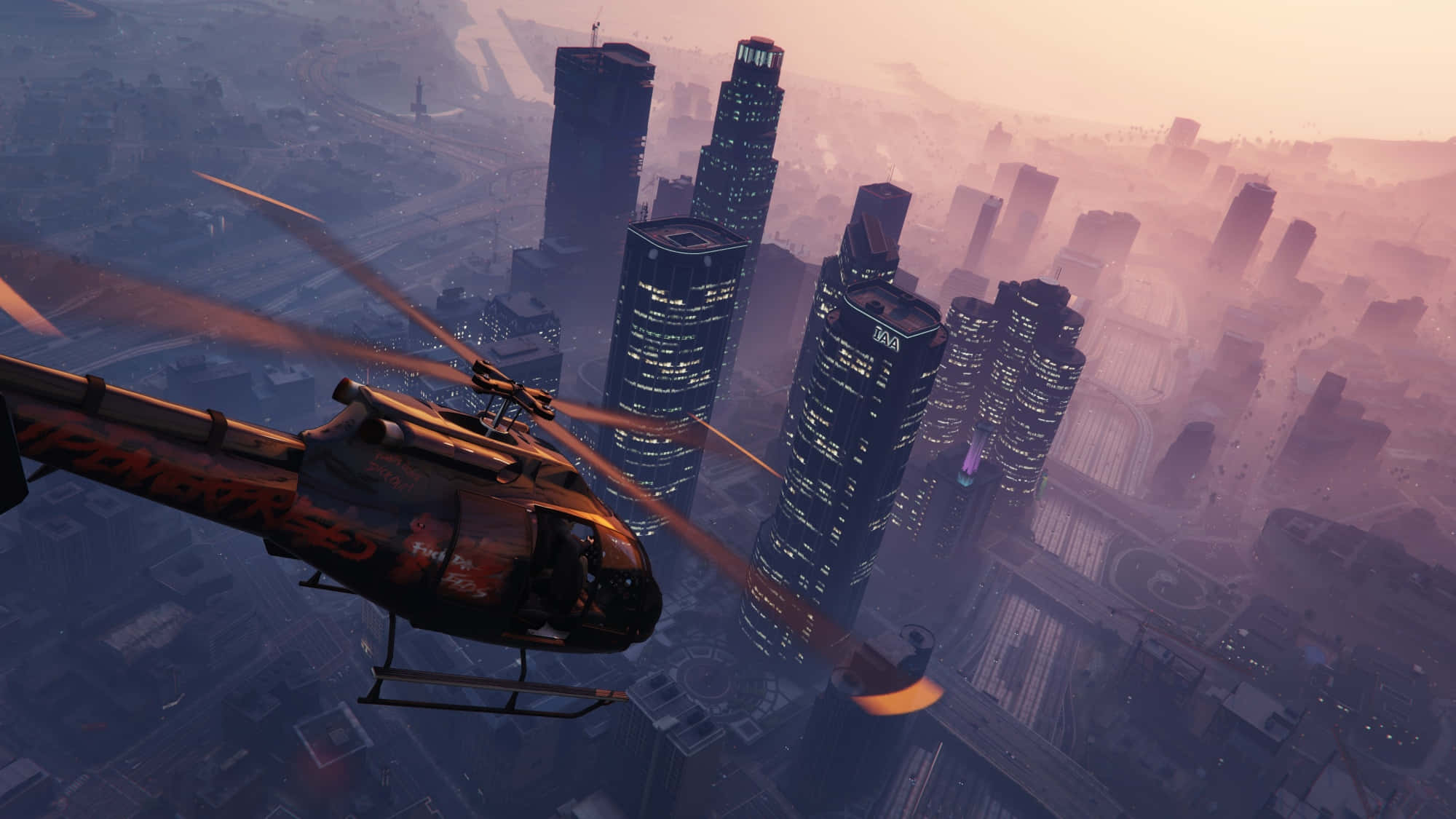 GTA中直升機俯瞰城市天際線 壁紙 — 一架直升機在黃昏時分低飛過廣闊的城市景觀，高聳的摩天大樓在朦朧的粉紅色天空中閃耀。