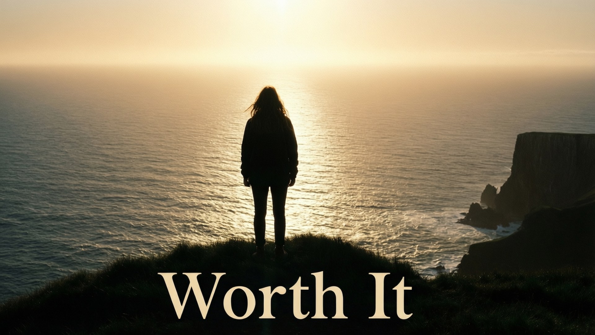 日落時分，人站在懸崖邊緣面向海洋，帶有文字 Worth It