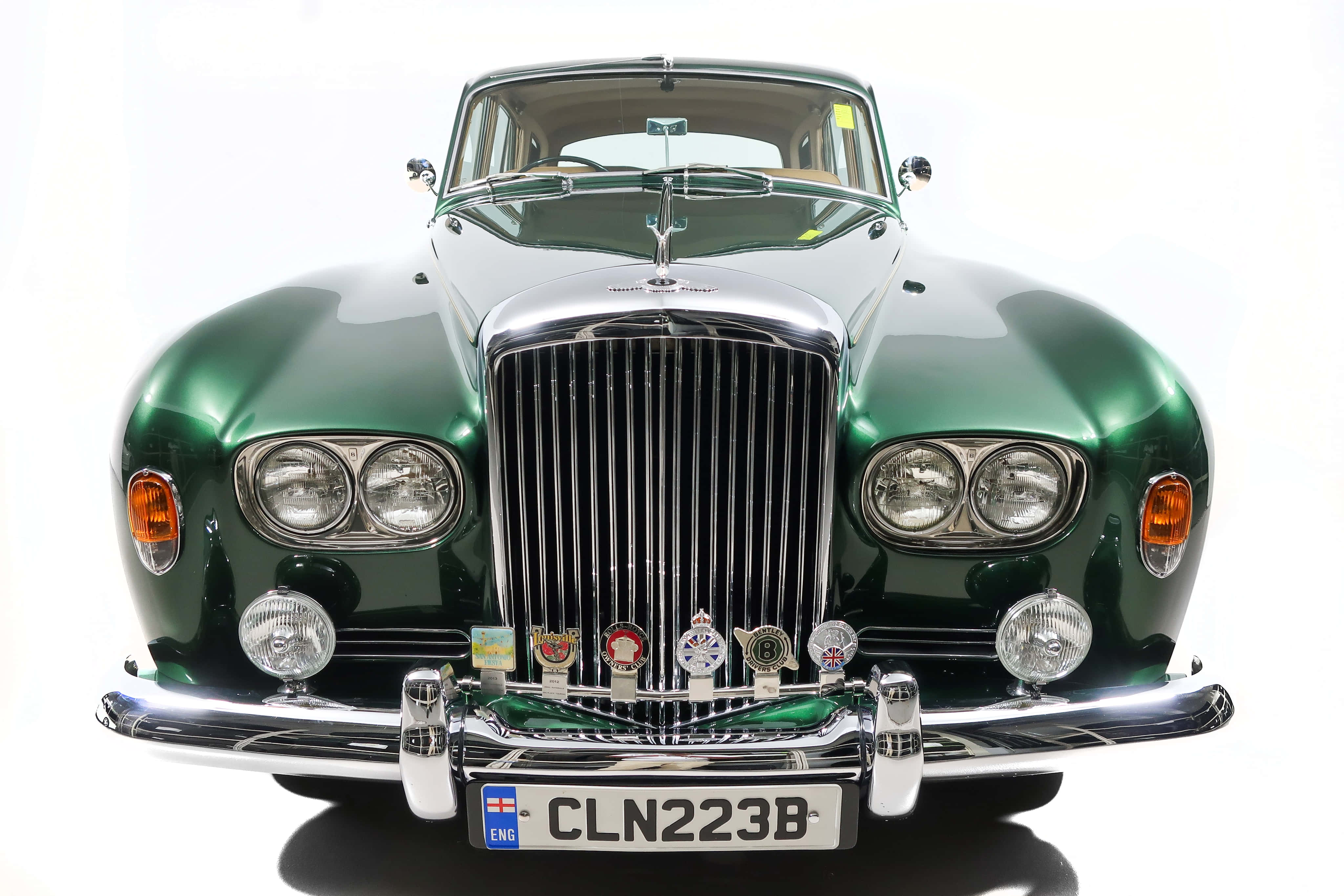 Bentley S3 桌布 壁紙 — 一輛光澤綠色經典Jaguar Mark 2，配備鍍鉻格柵和圓形頭燈，在純白背景下矗立。