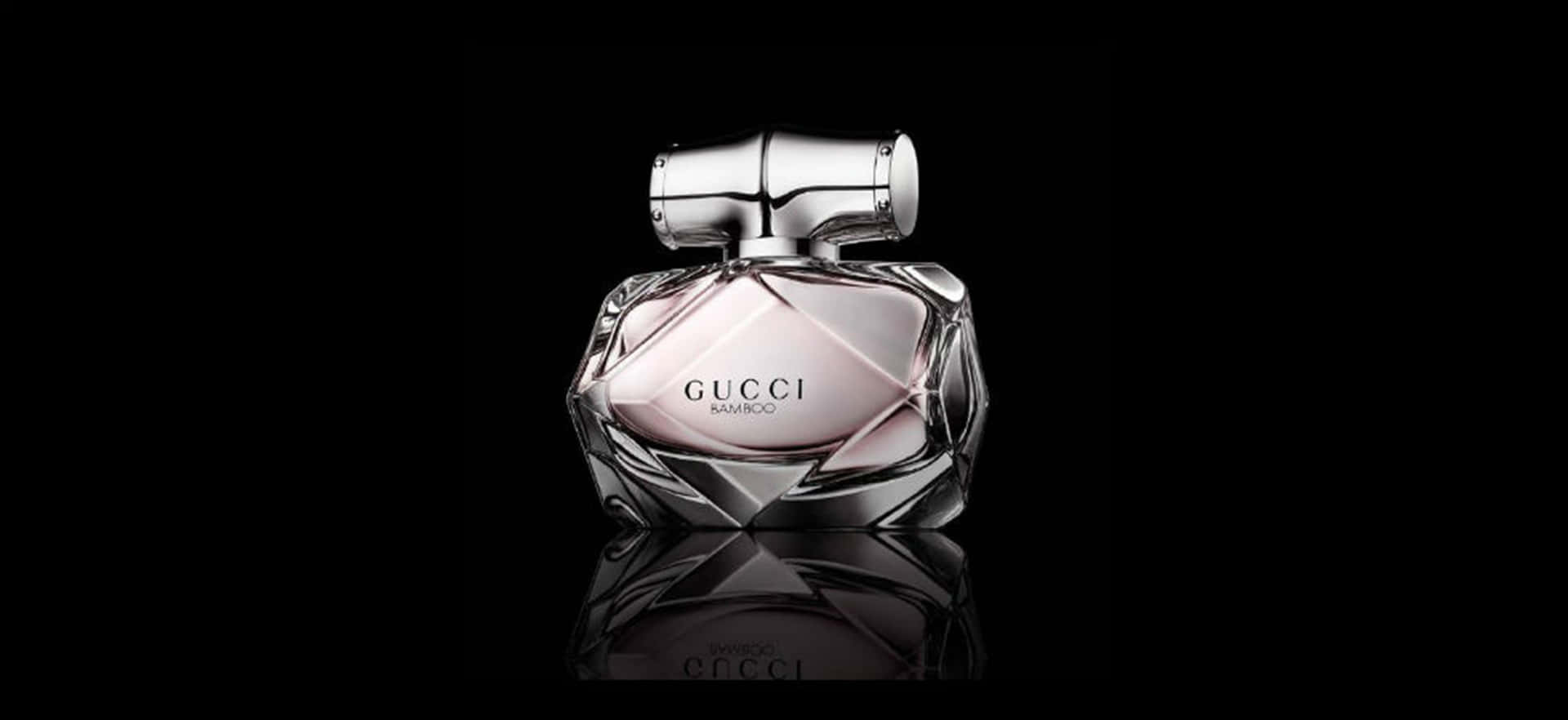 Gucci Bamboo香水瓶，銀色瓶蓋，置於黑色反光表面。
