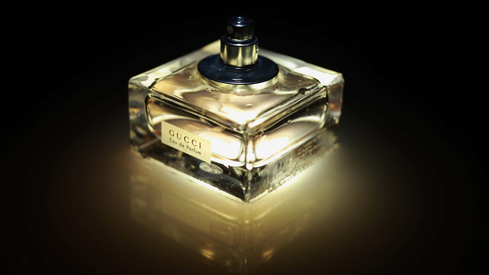 Gucci香水瓶在深色反光表面上散發溫暖光芒。