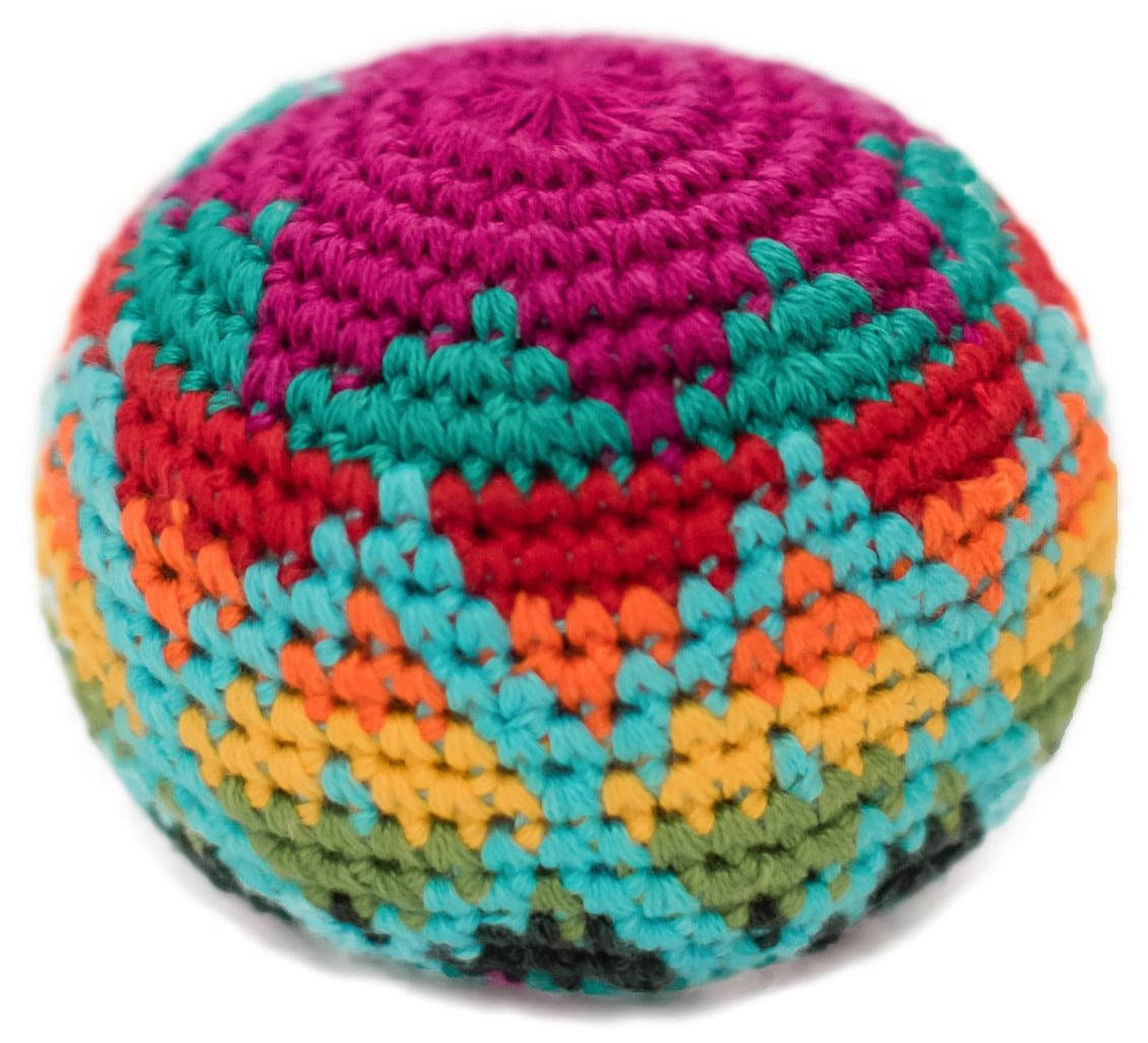 彩虹色編織Hacky Sack 壁紙 — 一個充滿活力的手工鉤針球形坐墊，在純白背景上帶有同心彩虹條紋。