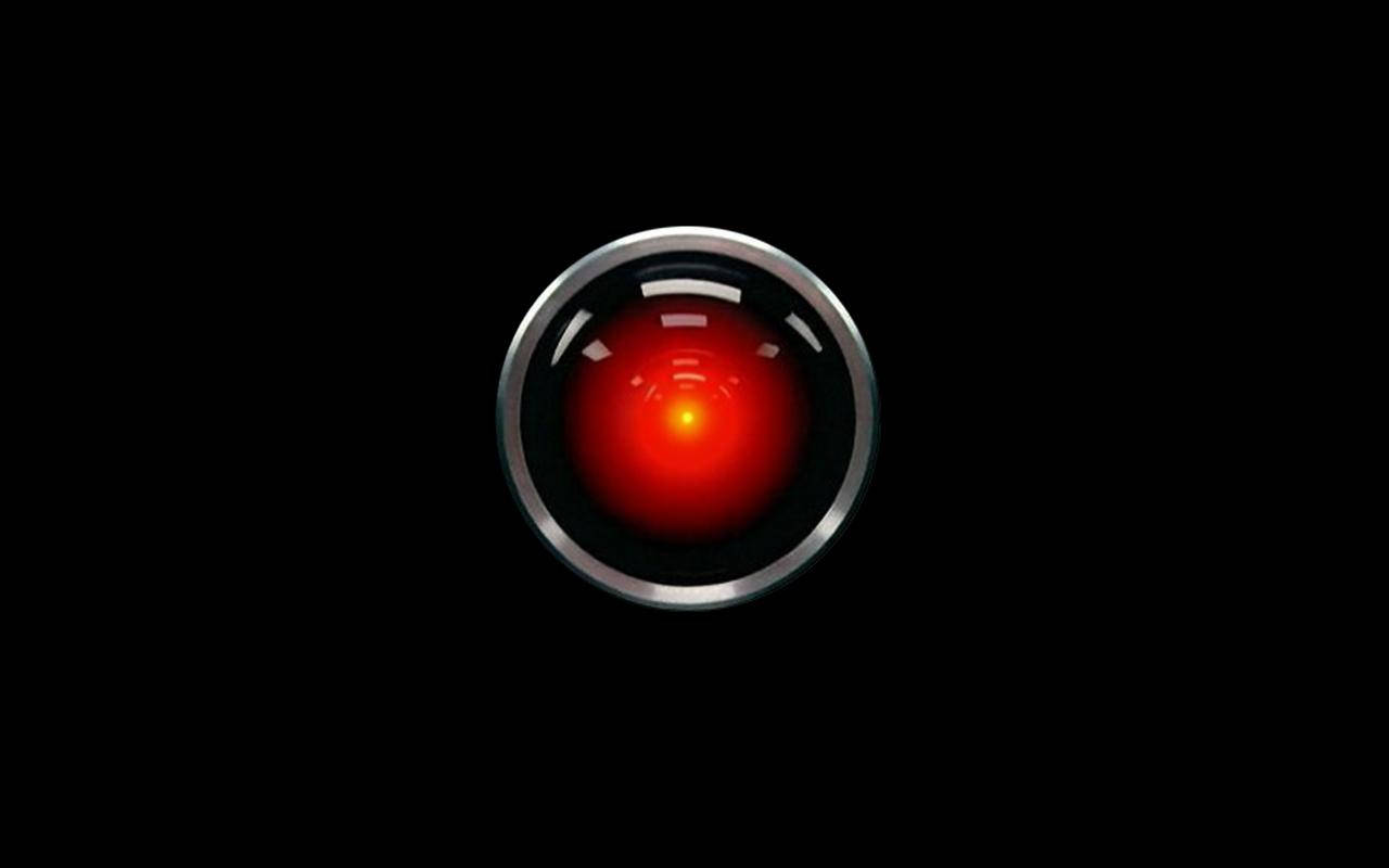 HAL 9000，史蒂芬·庫布里克電影《2001太空漫遊》中的經典超級電腦 壁紙 — 黑色背景上，一個發光的紅色眼睛在鉻環中，散發出威脅性的未來感。