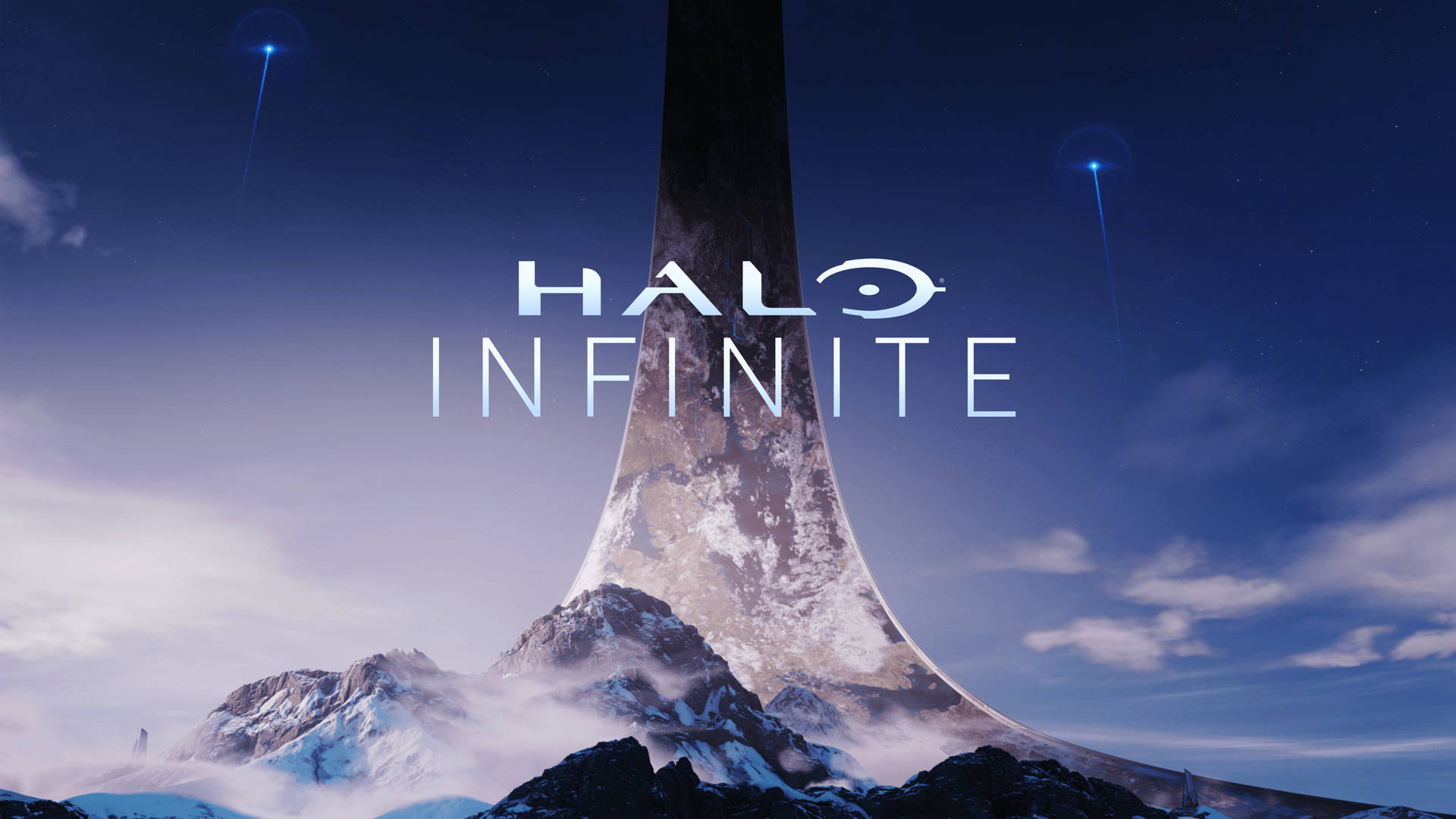 Halo Infinite標誌位於一個從雪山上出現的巨大環之上，時值黃昏。
