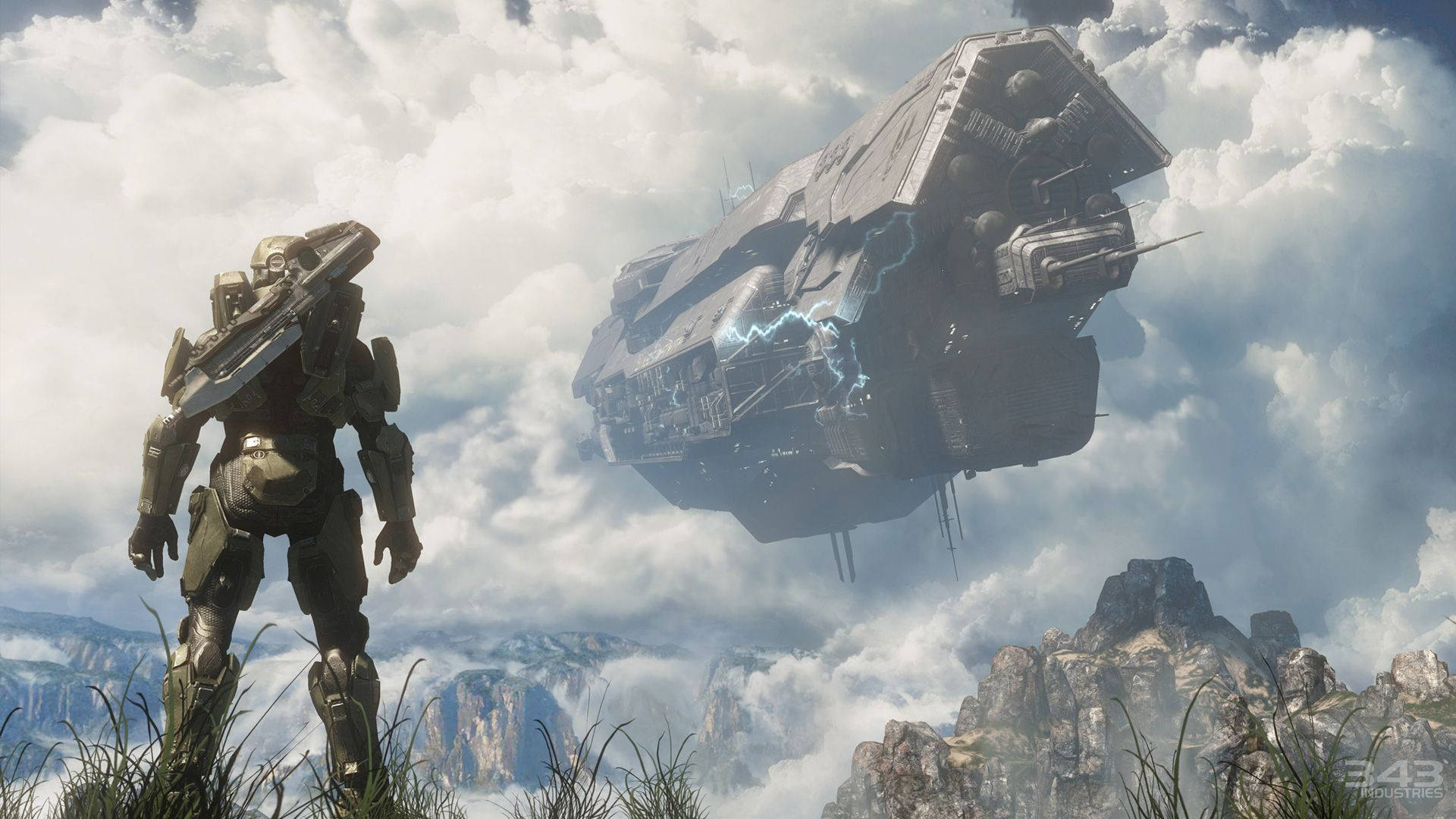 Halo Infinite 飛船 壁紙 — 一名身穿重型盔甲的士兵站在長滿草的懸崖上，俯瞰著一艘懸浮在山區景觀上空的巨大未來戰艦。